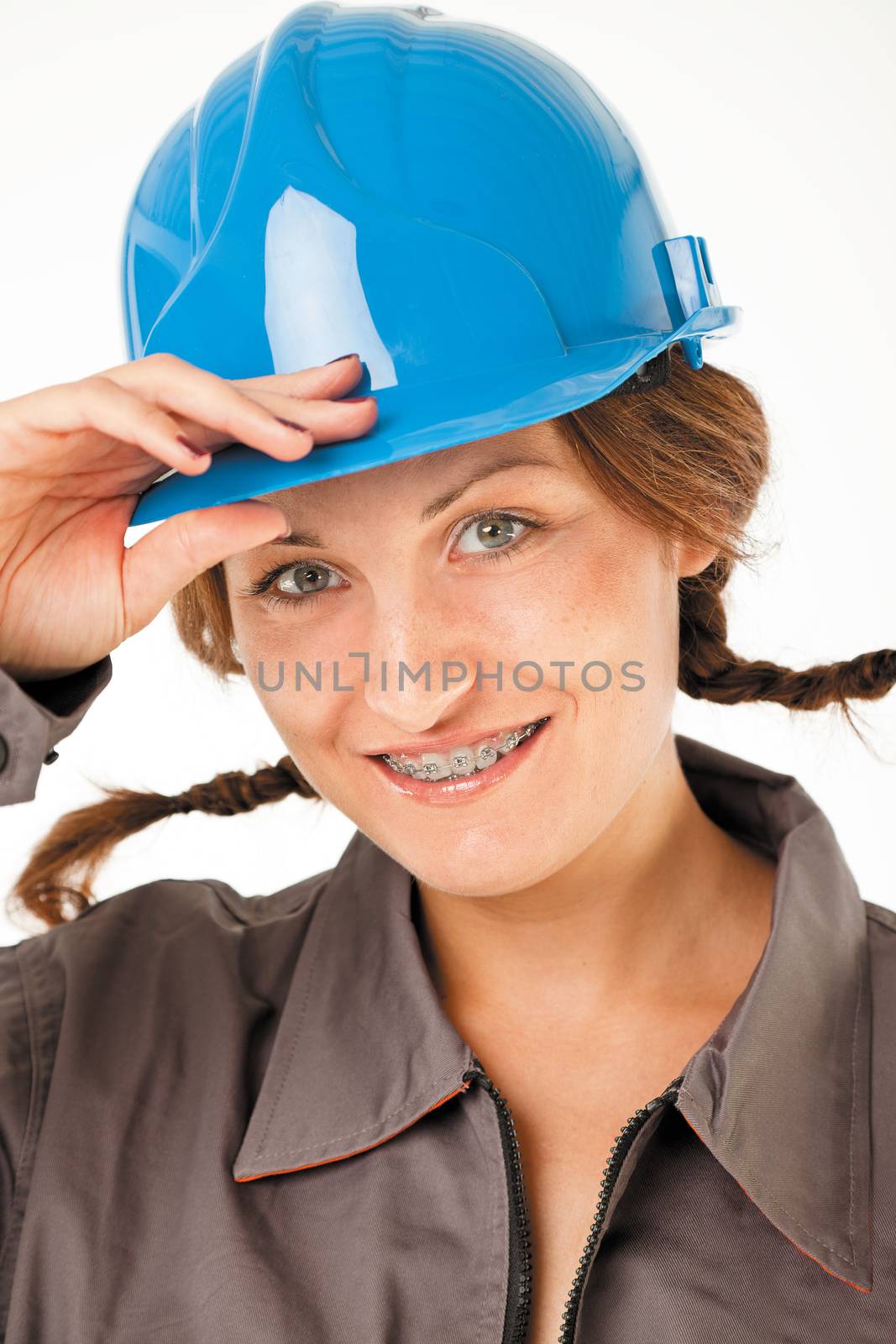 Close-up of female worker with hardhat and braces smiling, studio on white