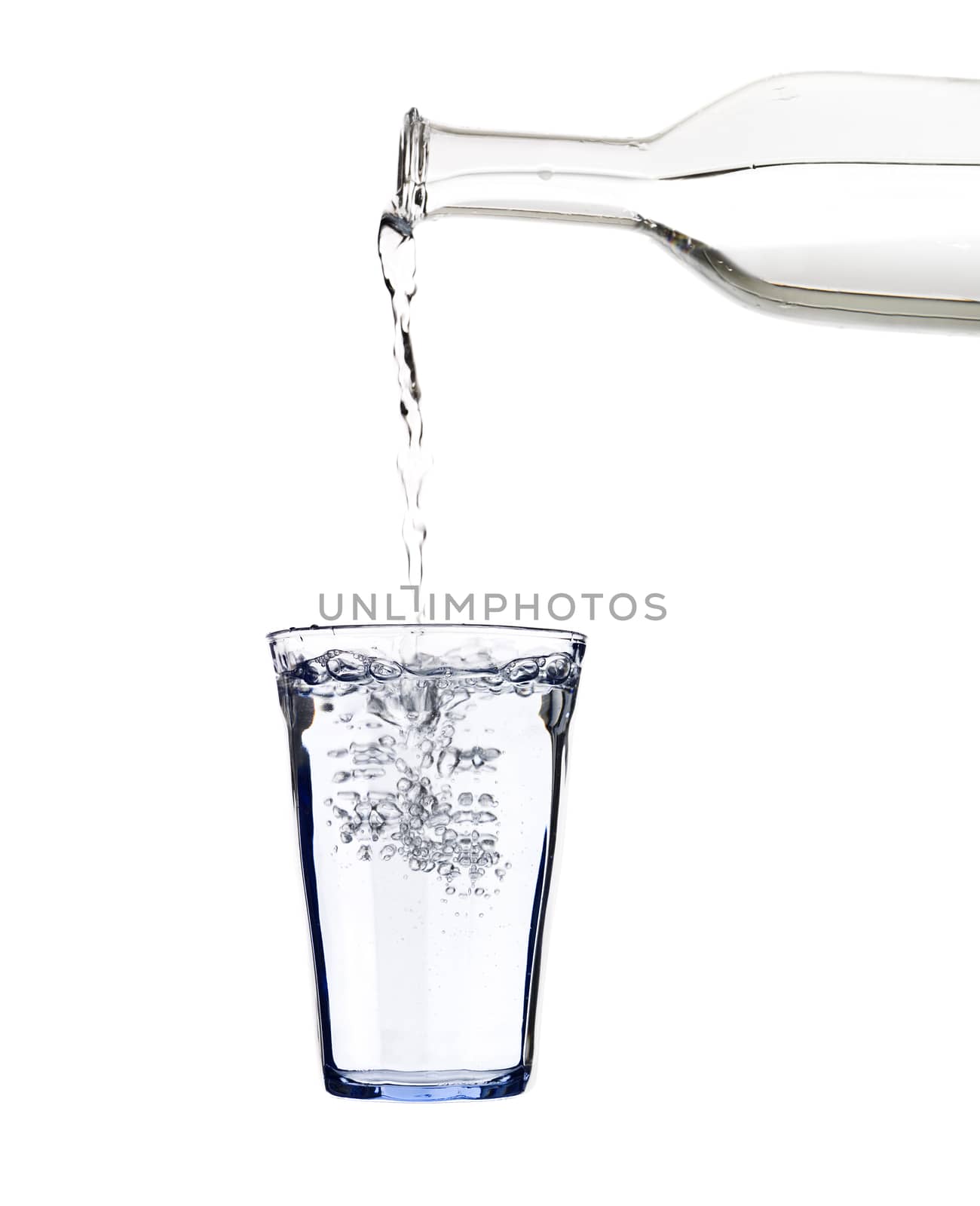 Pouring water in a glass isolated on white background