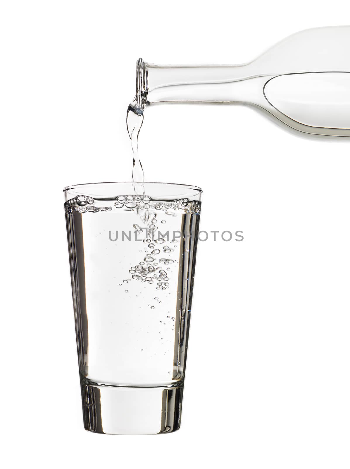 Pouring water in a glass isolated on white background