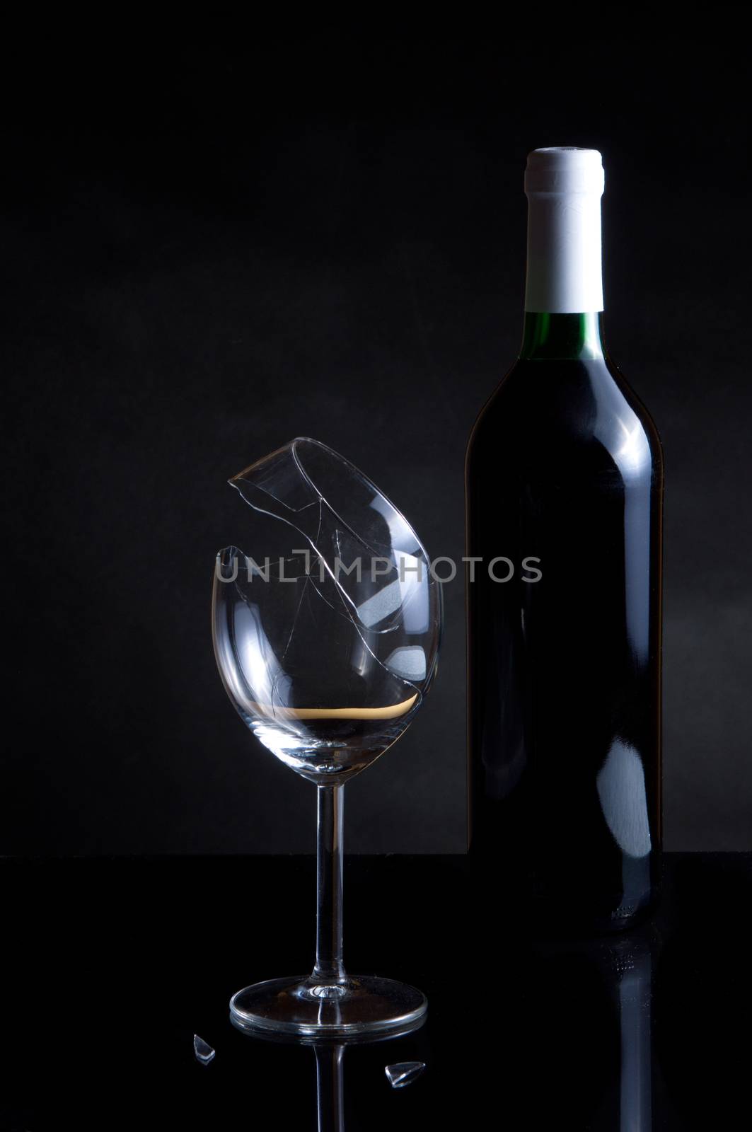 Vine bottle and broken glass on dark background