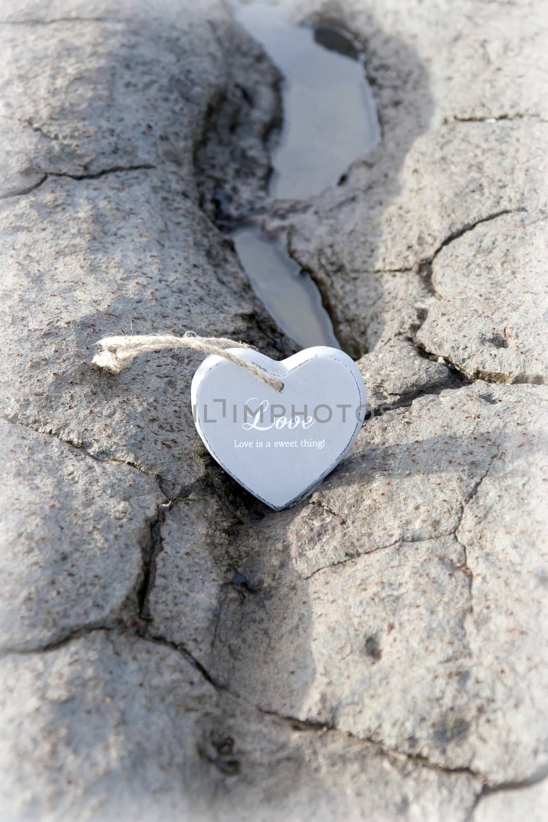 couple of wooden love hearts on the sand bank by morrbyte