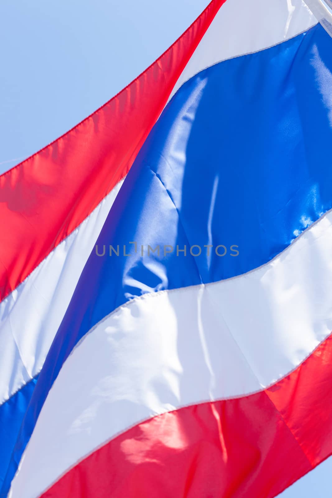 The Thai flag is waved pennants flutter. Behind the bright sky.