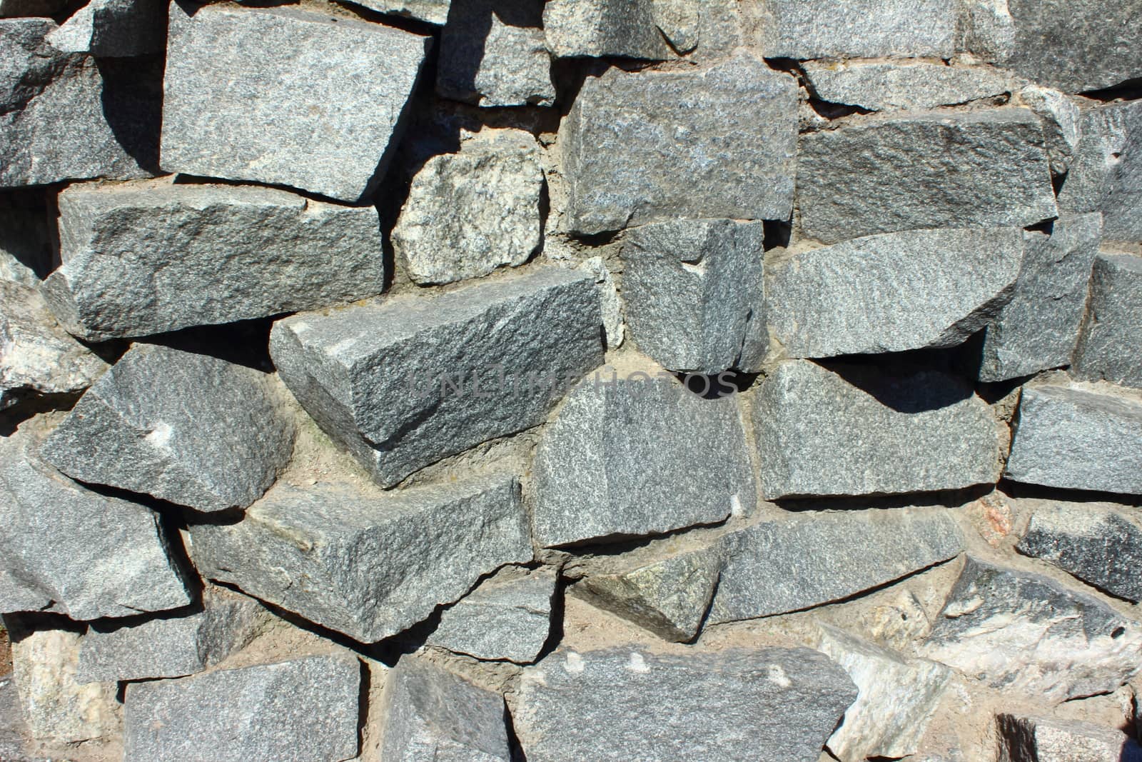 Large dark gray stones stacked as a wall