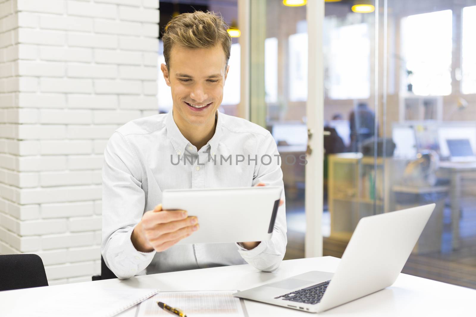 Businessman working on digital tablet in office by LDProd