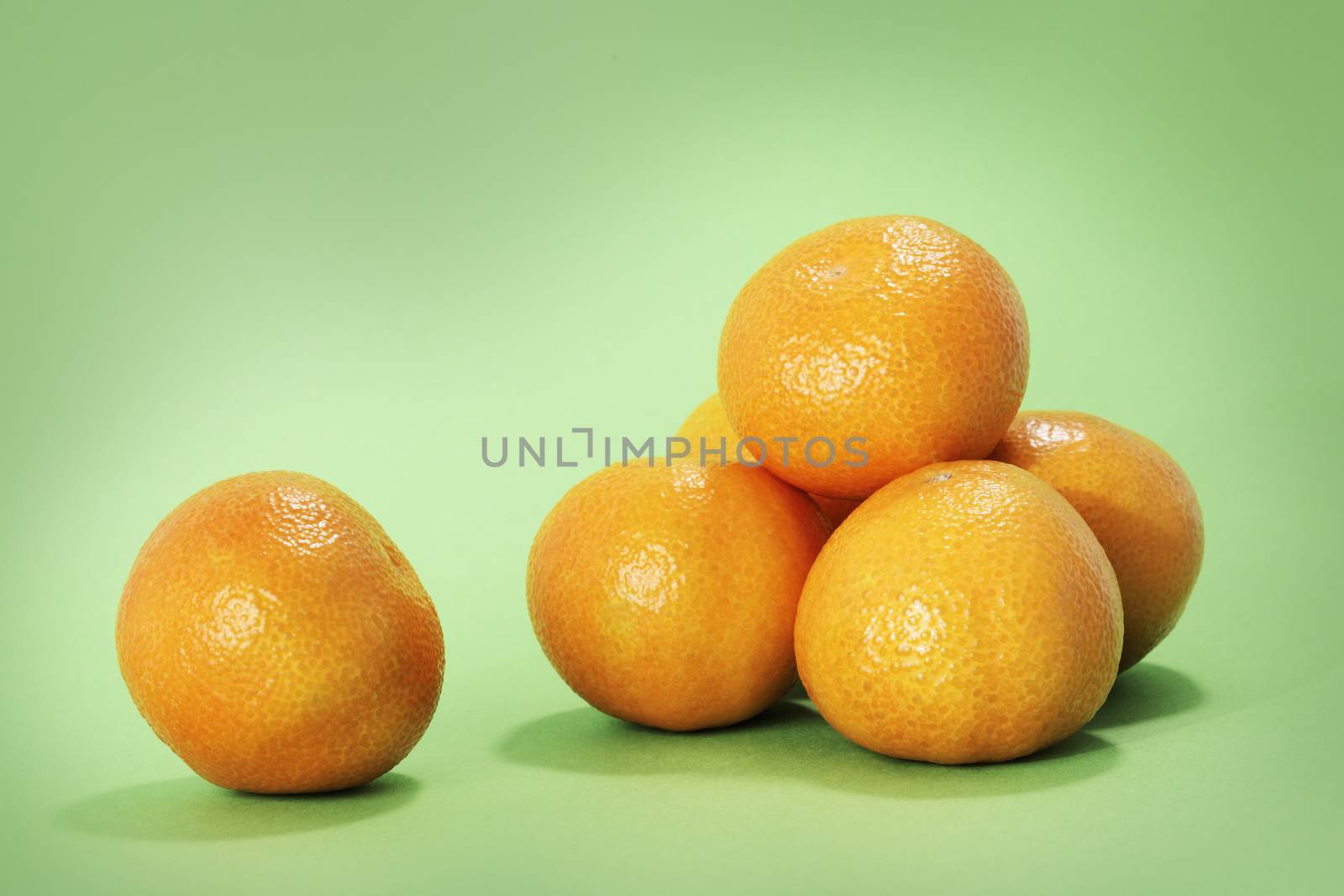 RIpe mandarin oranges on green background.