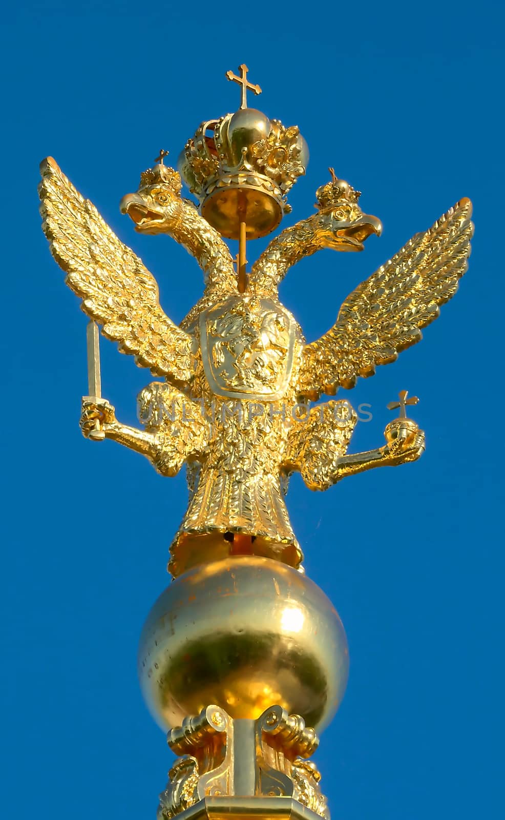 Two-headed golden eagle on the steeple in the Peterhof Palace against the blue sky