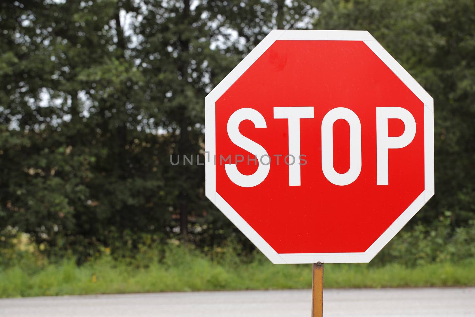 old STOP traffic sign at the side of a road.