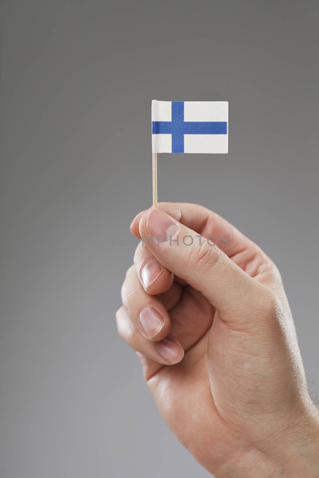 Man holding a tiny Finnish flag in his hand.