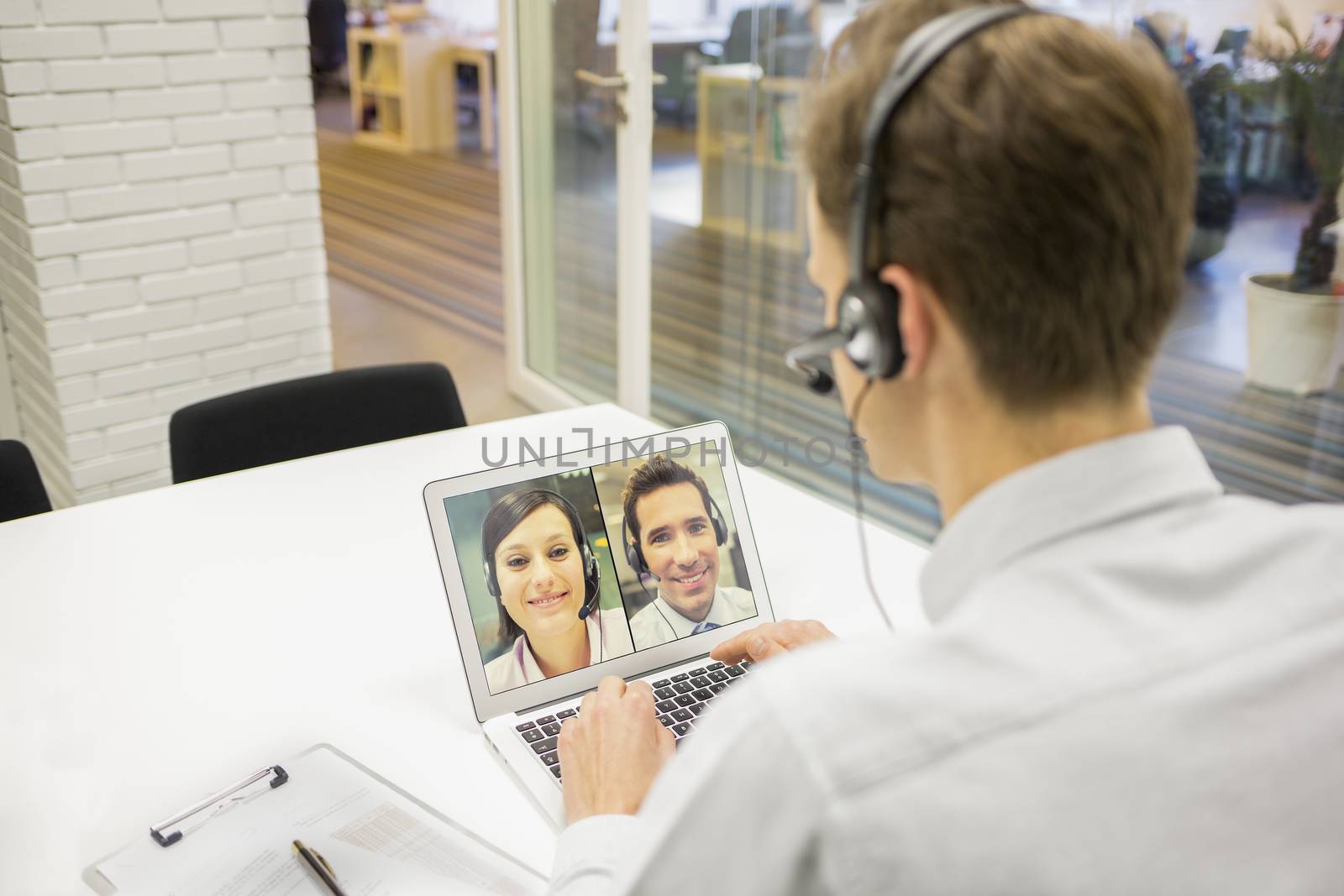 Businessman in the office on videoconference with headset, Skype by LDProd