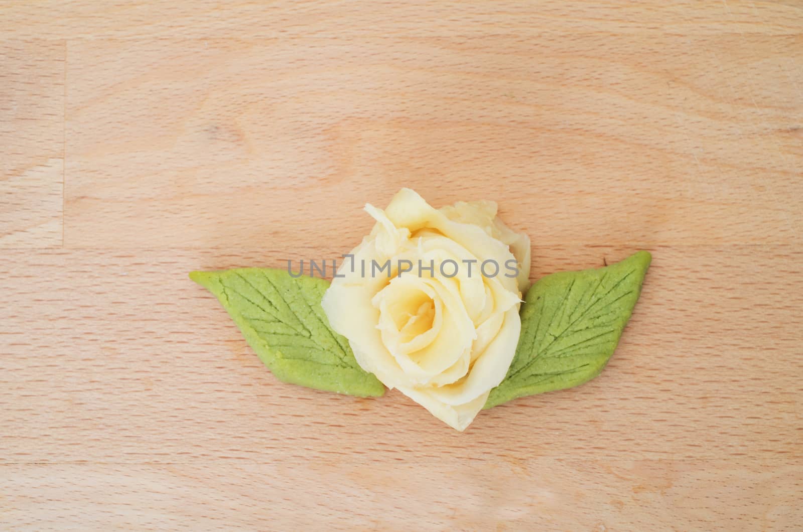 Rose made with marinated japanese  ginger and green wasabi on wooden cutting board