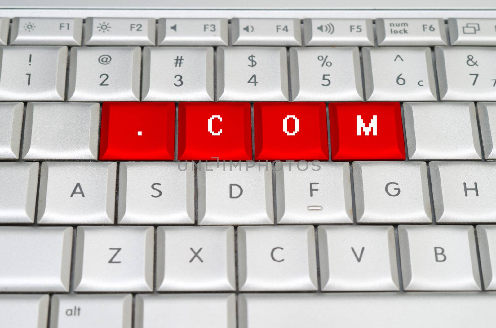 Internet top level domain .com spelled on metallic keyboard