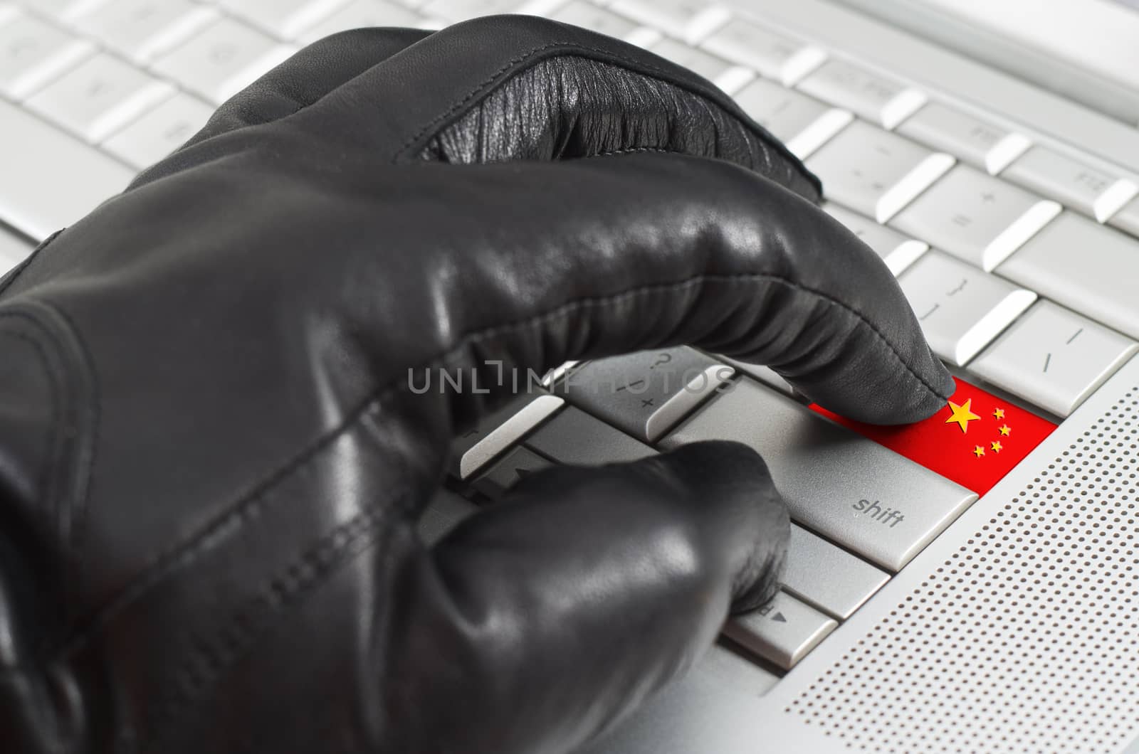 Hacking China concept with hand wearing black leather glove pressing enter key with flag overlaid