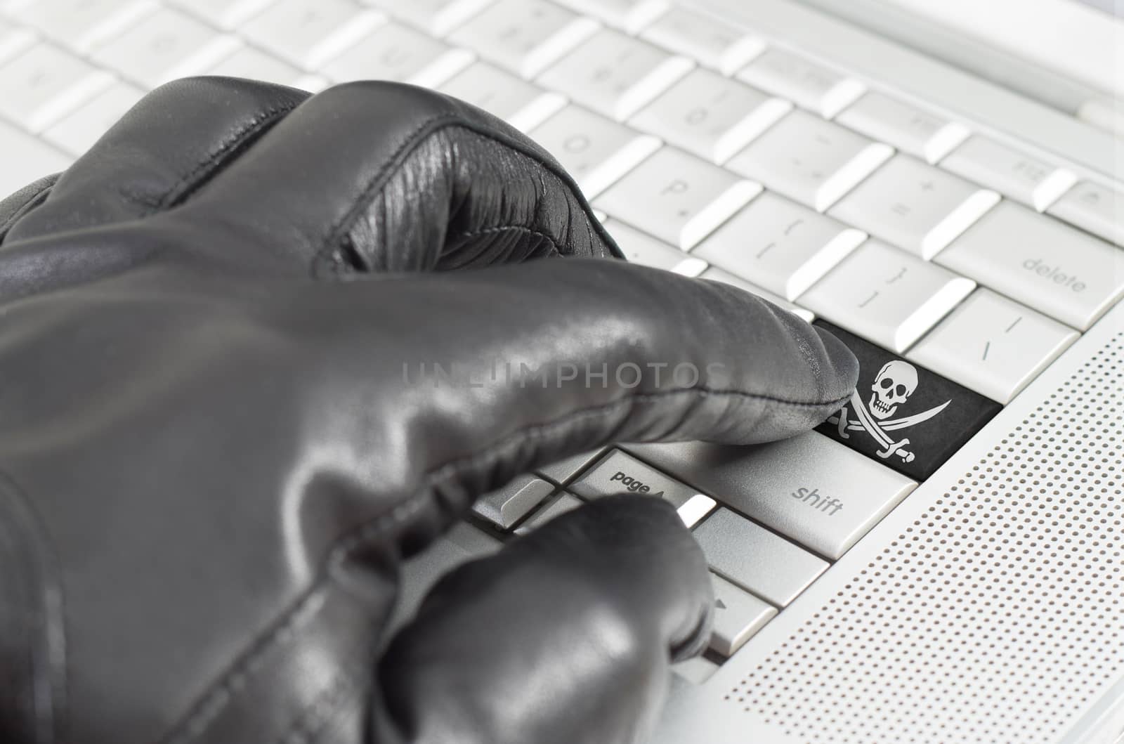 Hacking concept with hand wearing black leather glove pressing enter key with flag overlaid