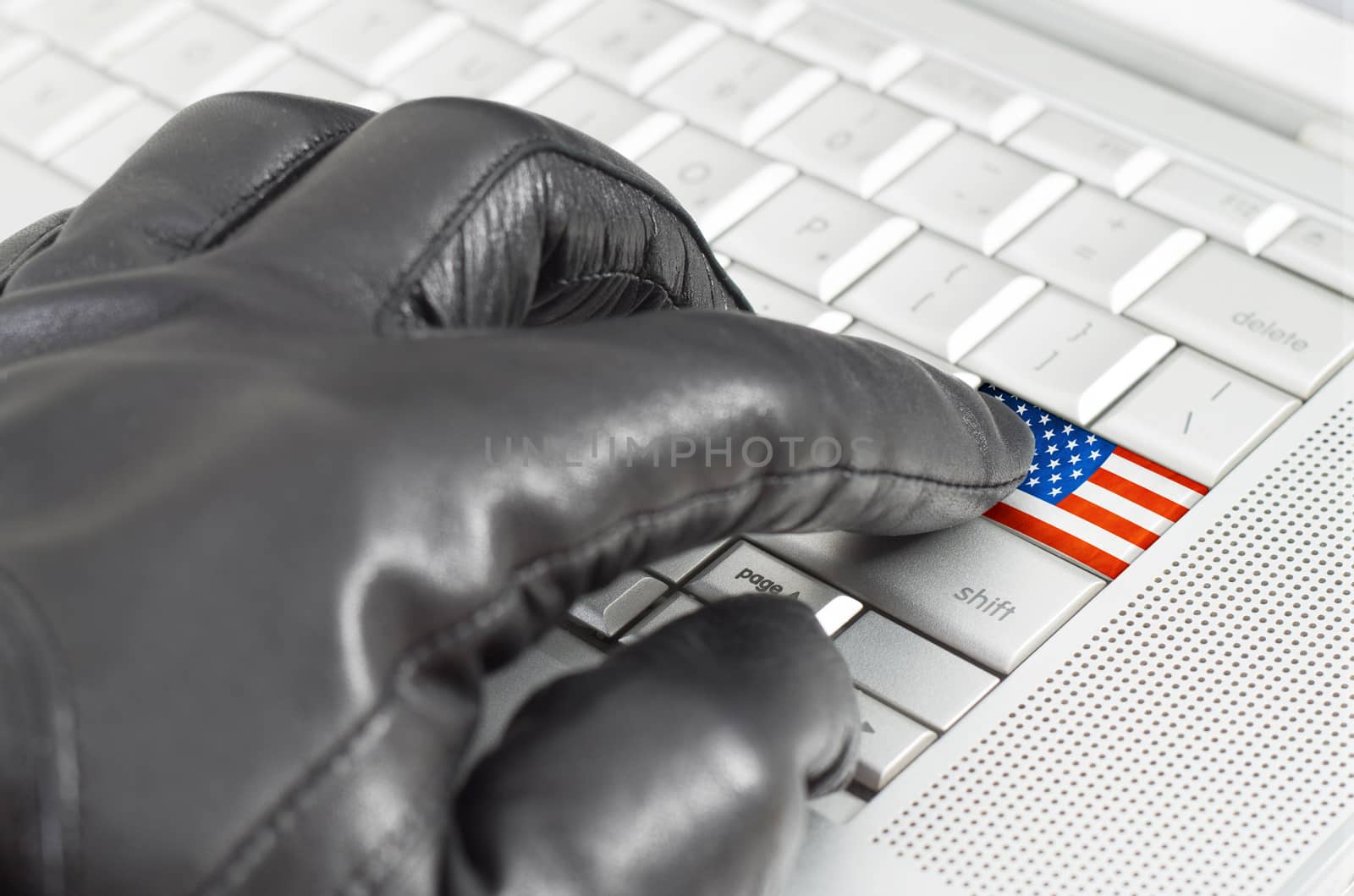 Hacking USA concept with hand wearing black leather glove pressing enter key with flag overlaid