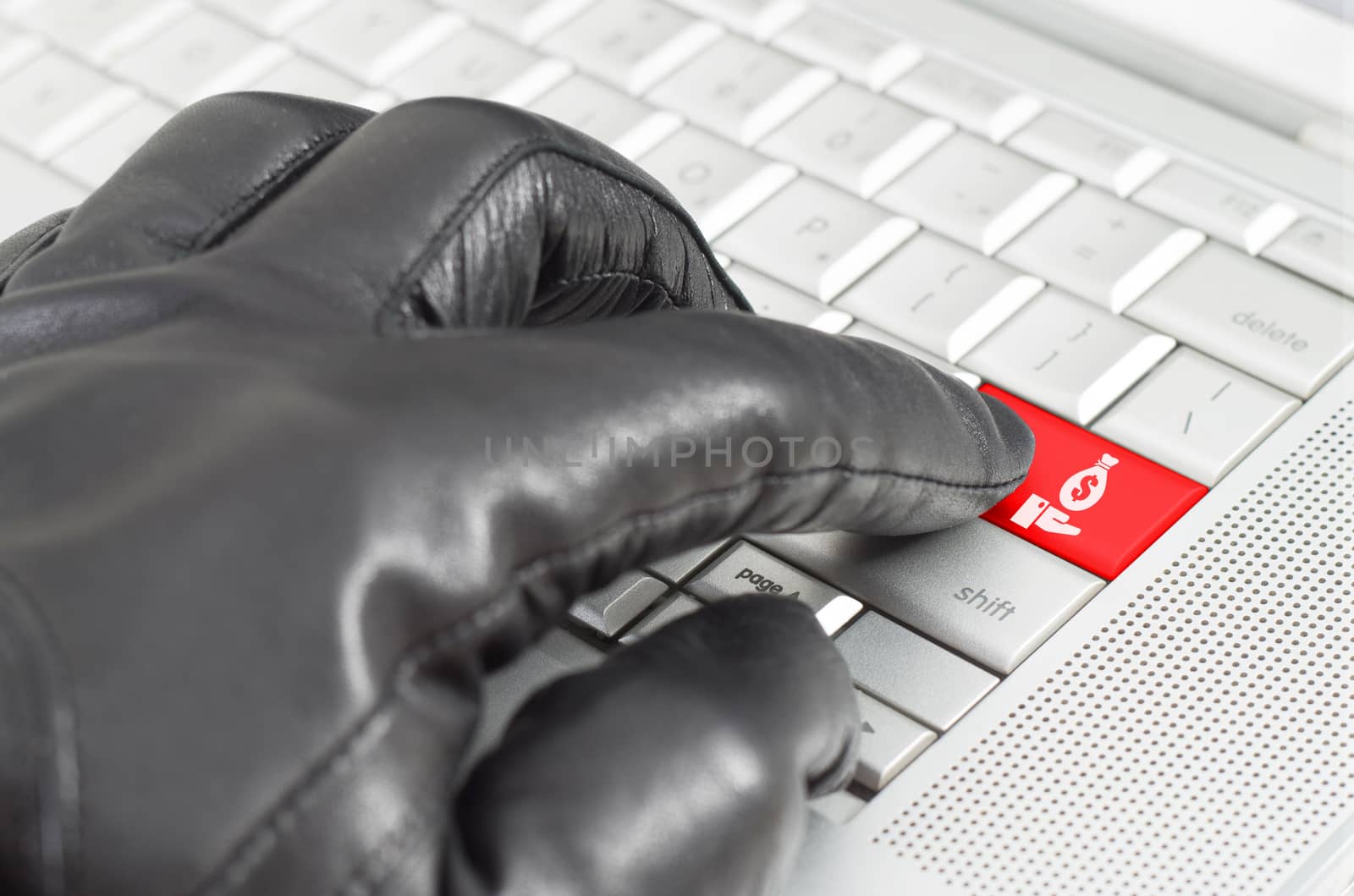 Online financial hacking concept with hand wearing black leather glove pressing enter key