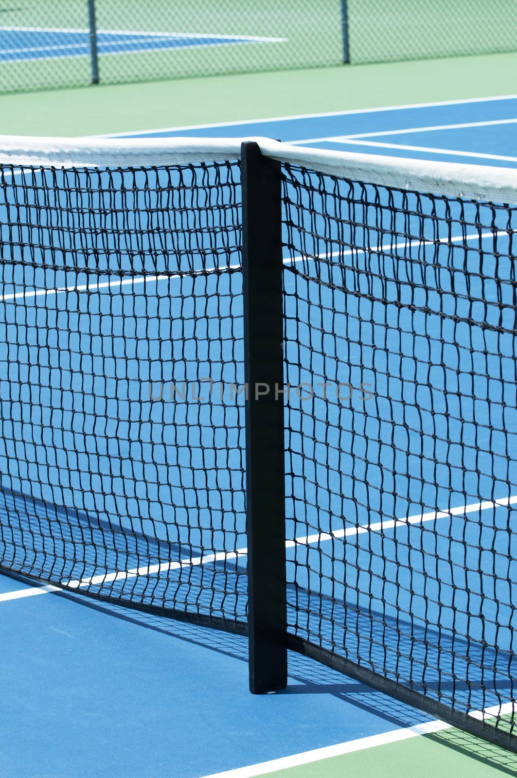 Outdoor tennis court focus on the net support by daoleduc