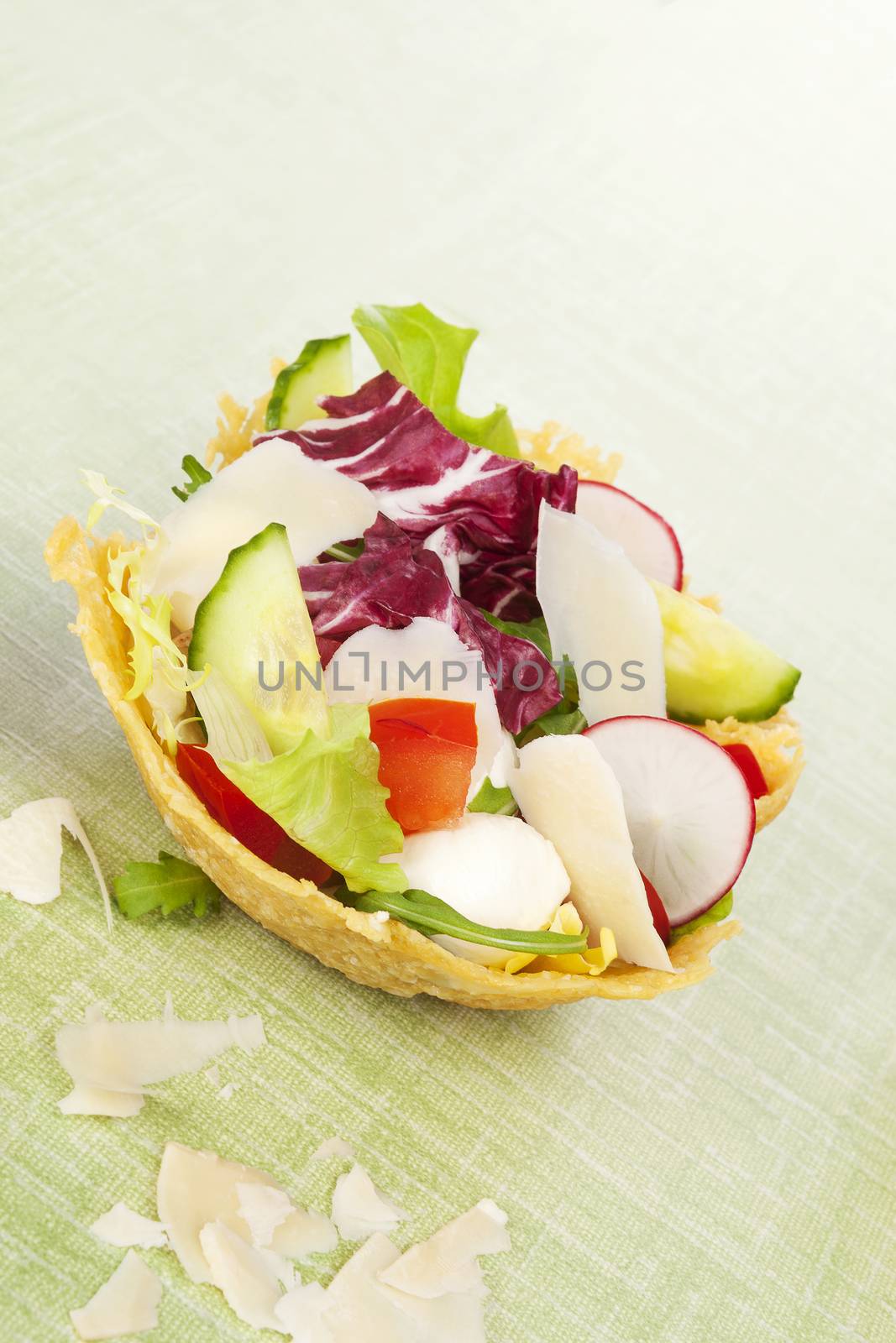Cheese basket filled with fresh vegetable salad and bacon. Culinary eating.