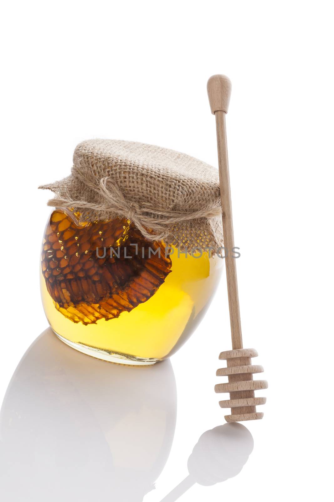 Golden honey with bee comb and wooden drizzler isolated on white background. Organic healthy natural sweetener.