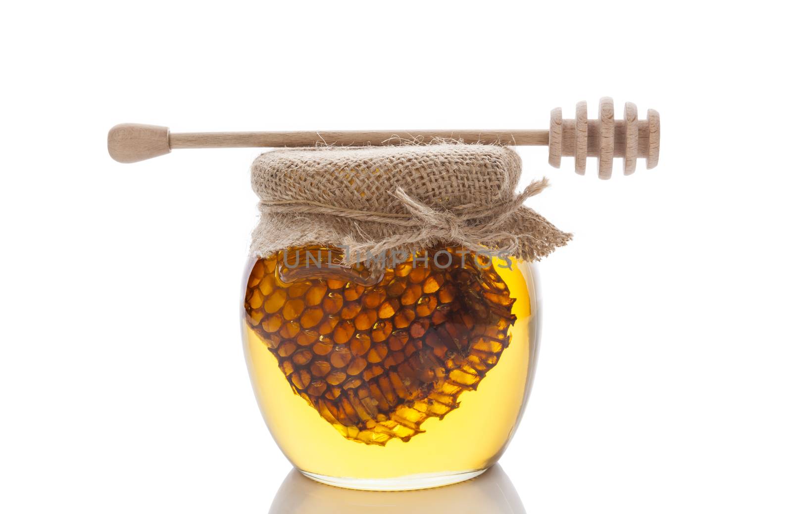 Honey in glass jar with wooden honey spoon and honey comb isolated on white background. Organic bee honey.