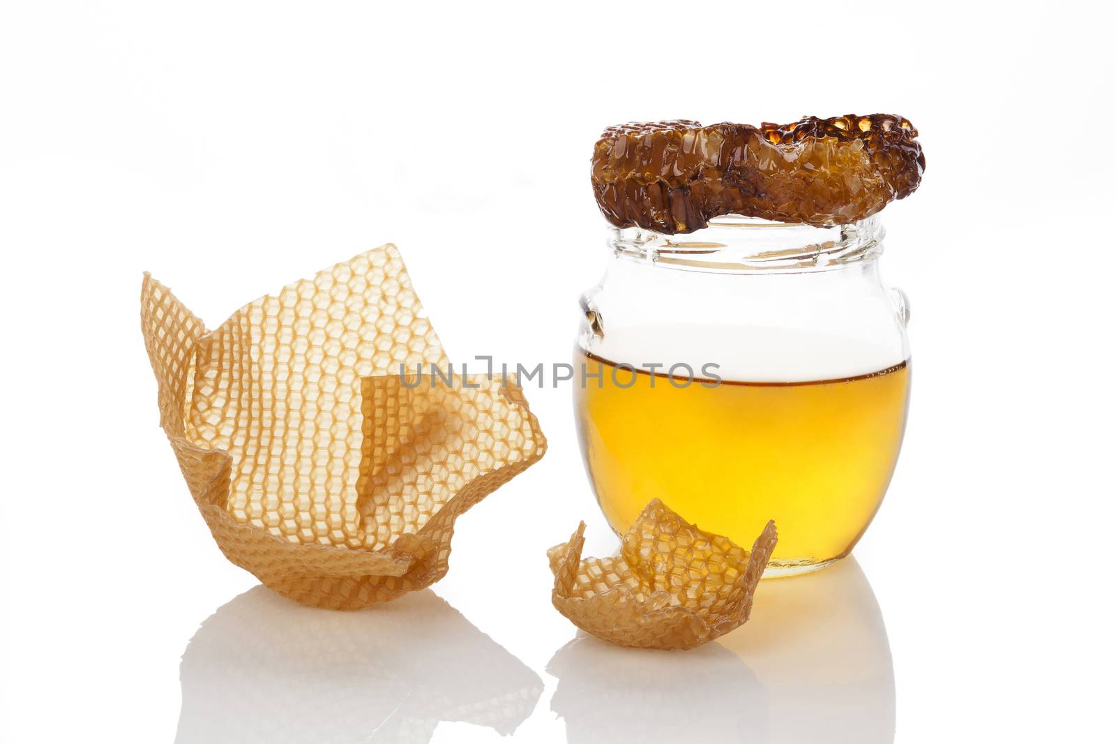 Organic honey with honey comb and honey cups isolated on white background. Natural healthy sweetener.