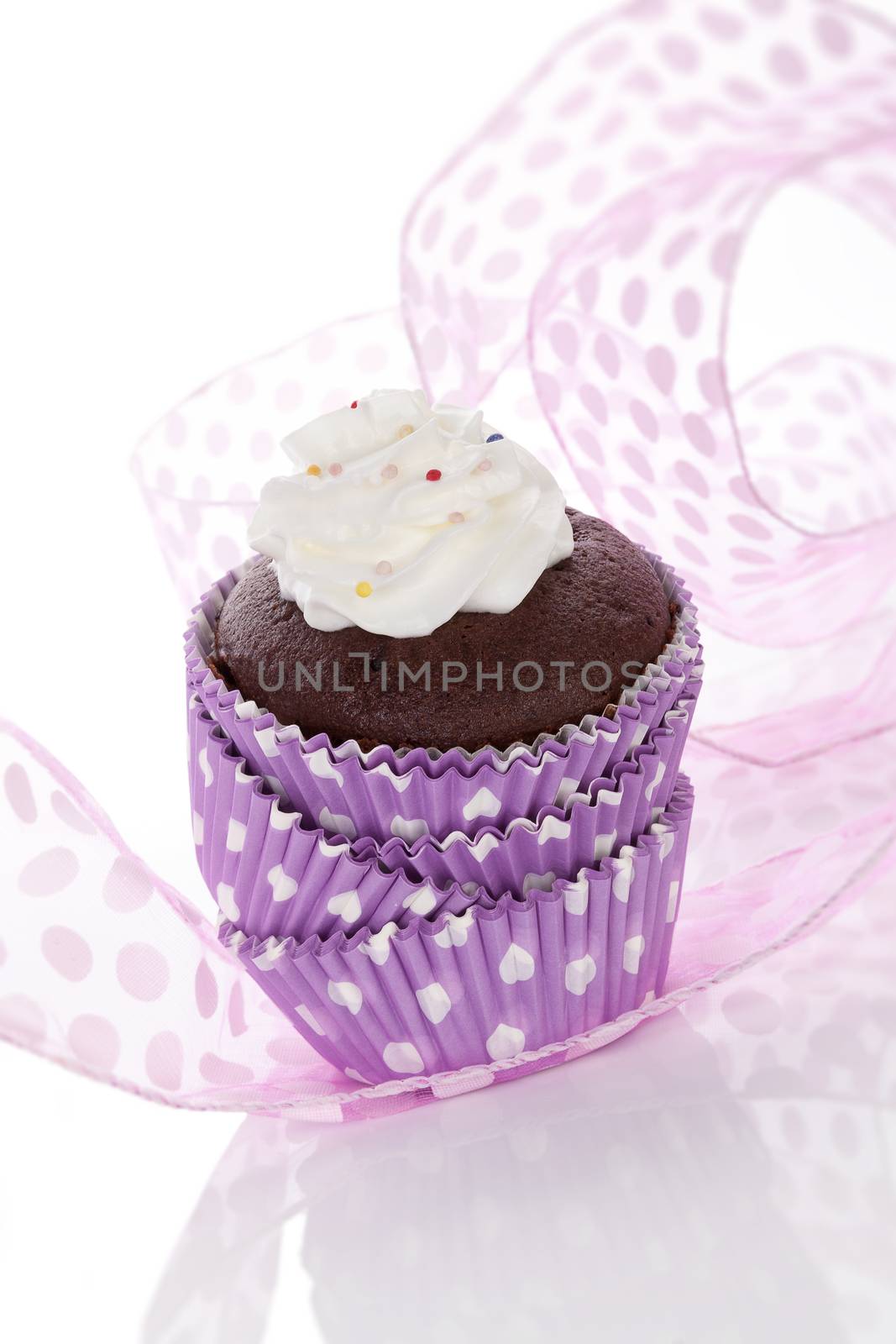 Cupcake. Delicious chocolate cupcake with whipped cream and colorful sprinkles isolated on white background. Contemporary baking concept.