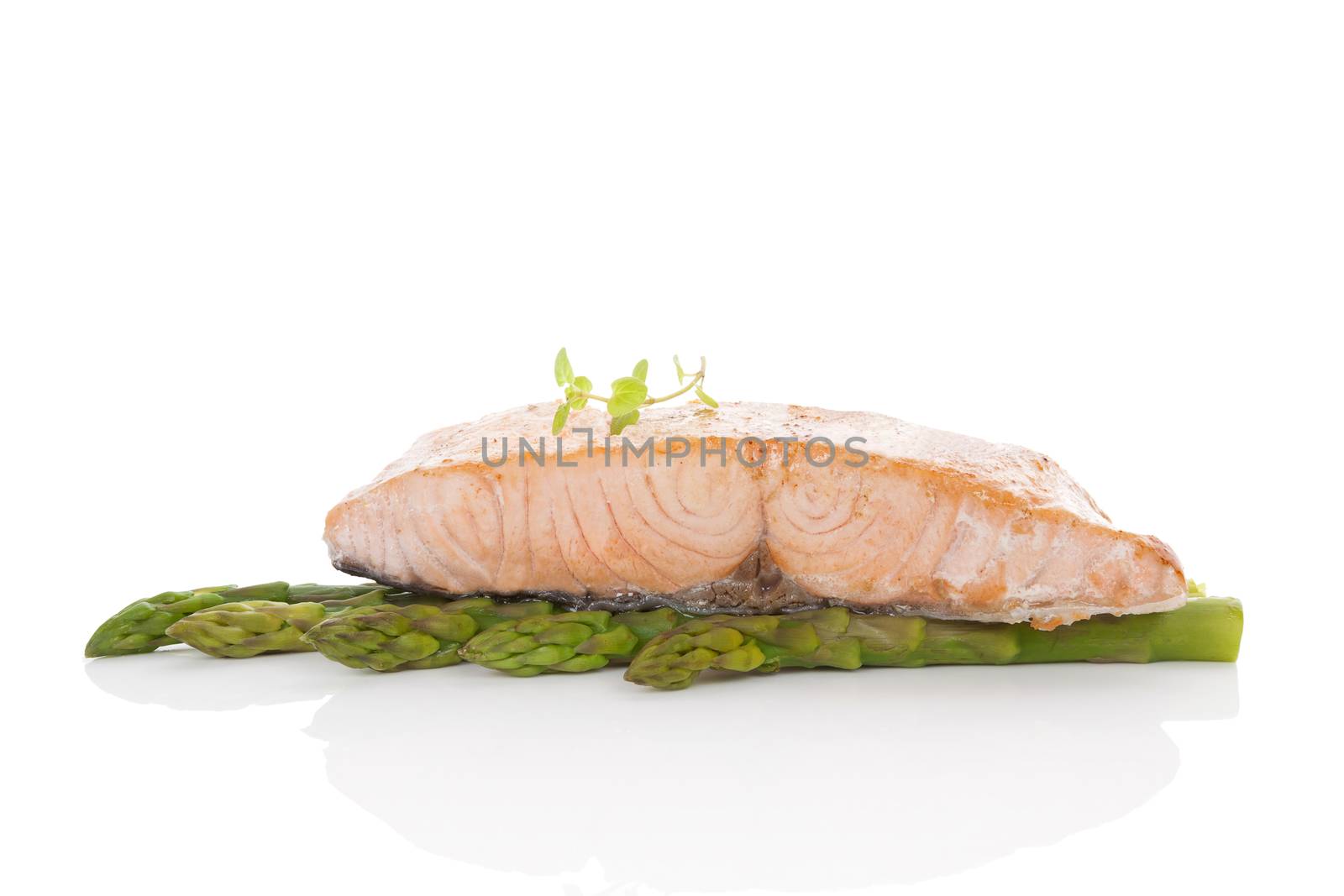Delicious salmon steak on green asparagus isolated on white background. Culinary seafood eating.