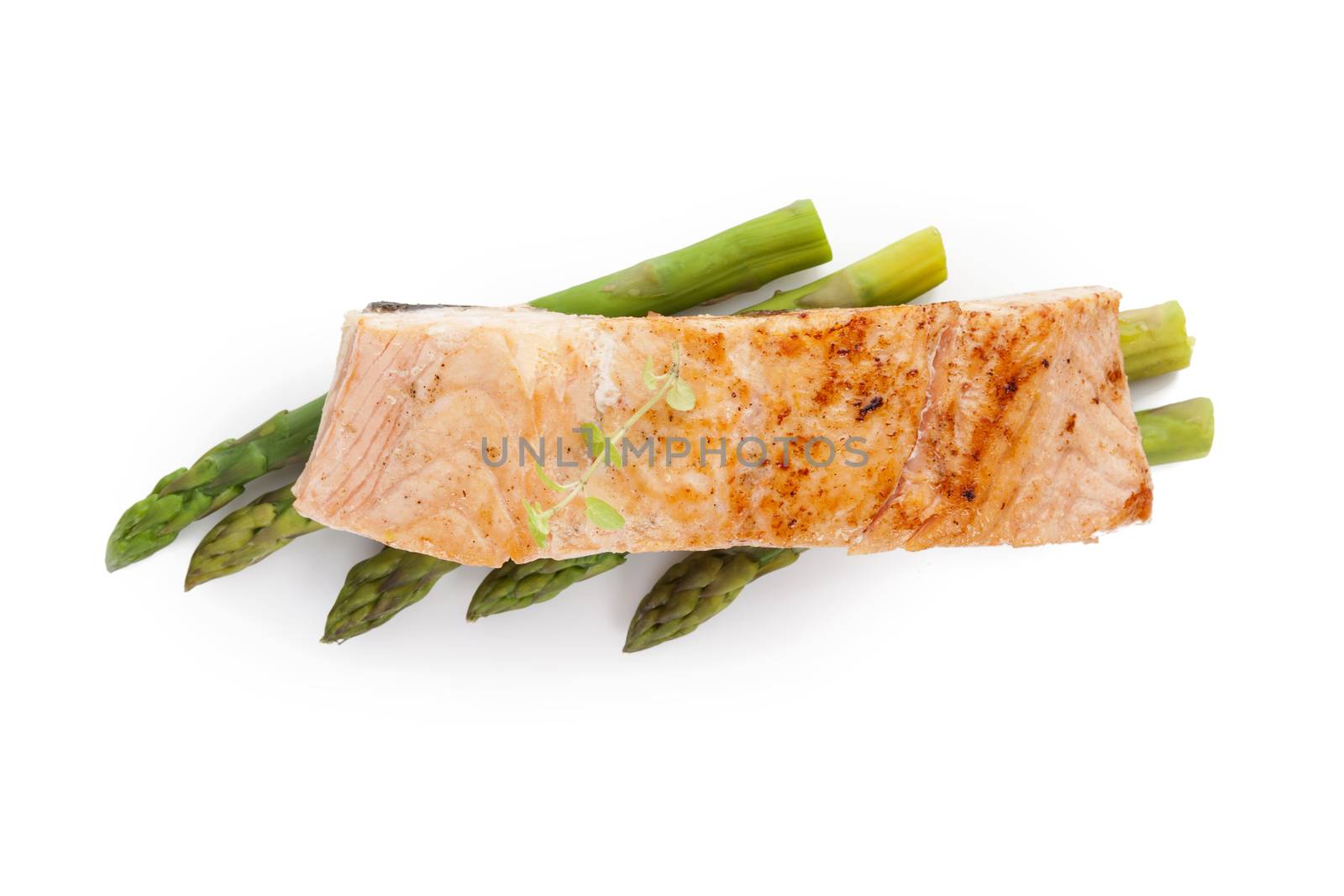 Delicious grilled salmon piece with fresh herbs on green asparagus on white background, top view. Healthy fish eating. 