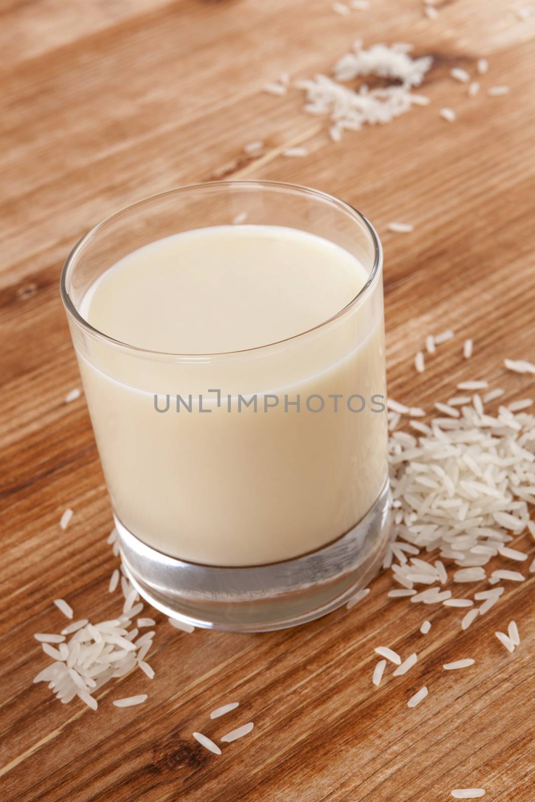 Rice milk on wooden background. Vegan milk drinking.