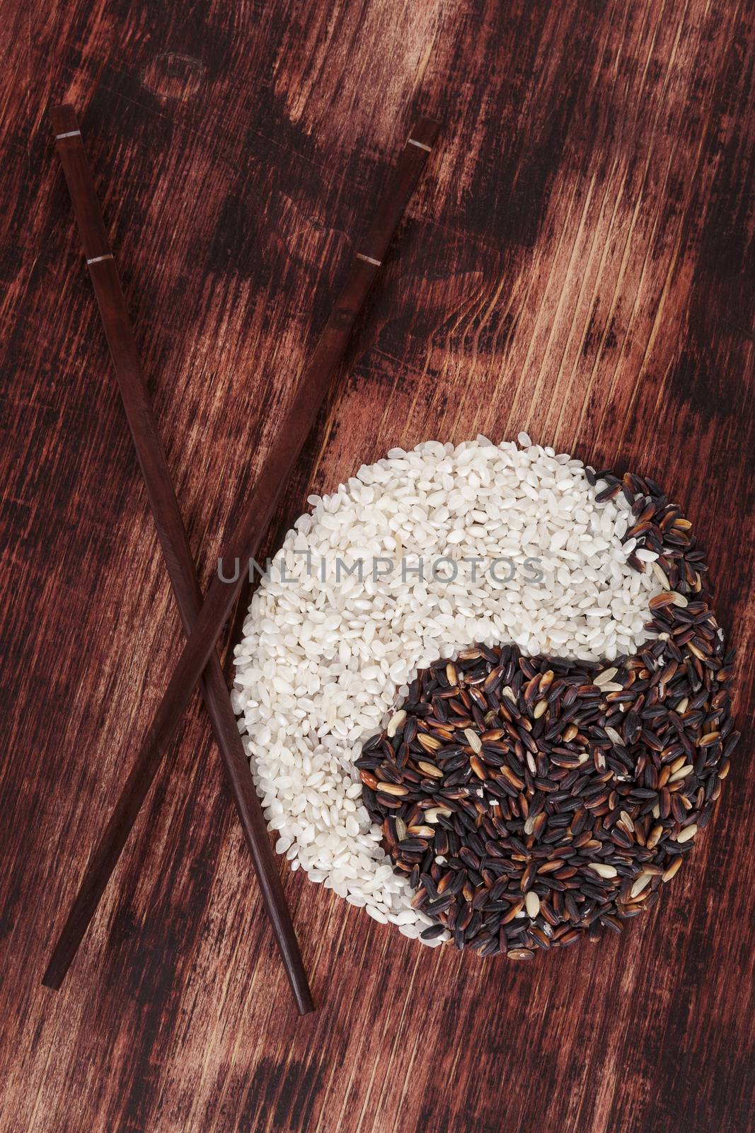 White and forbidden rice with chopsticks on dark wooden background. Top view. Healthy eating concept.