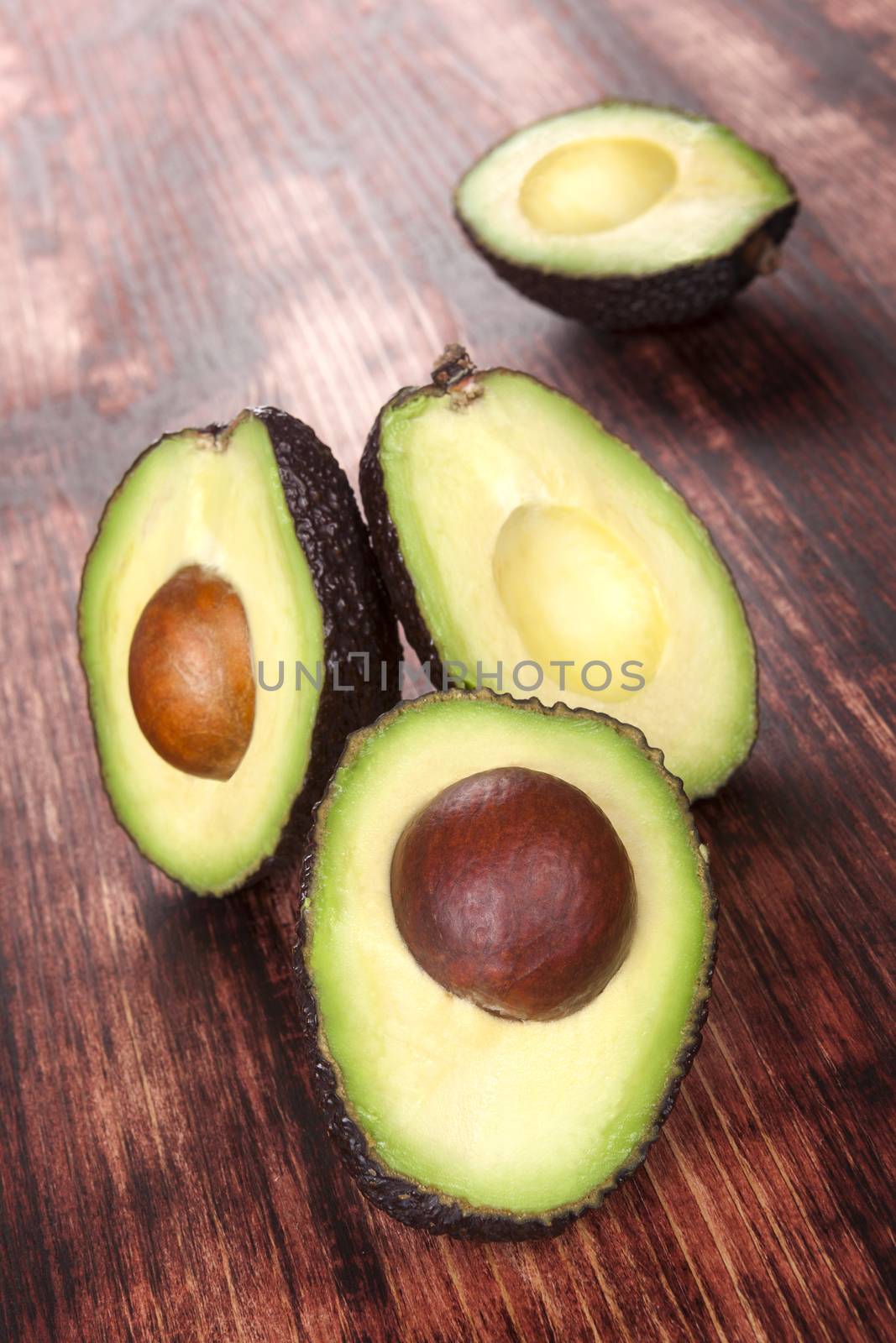 Delicious fresh ripe cut avocados on wooden background. Healthy eating.
