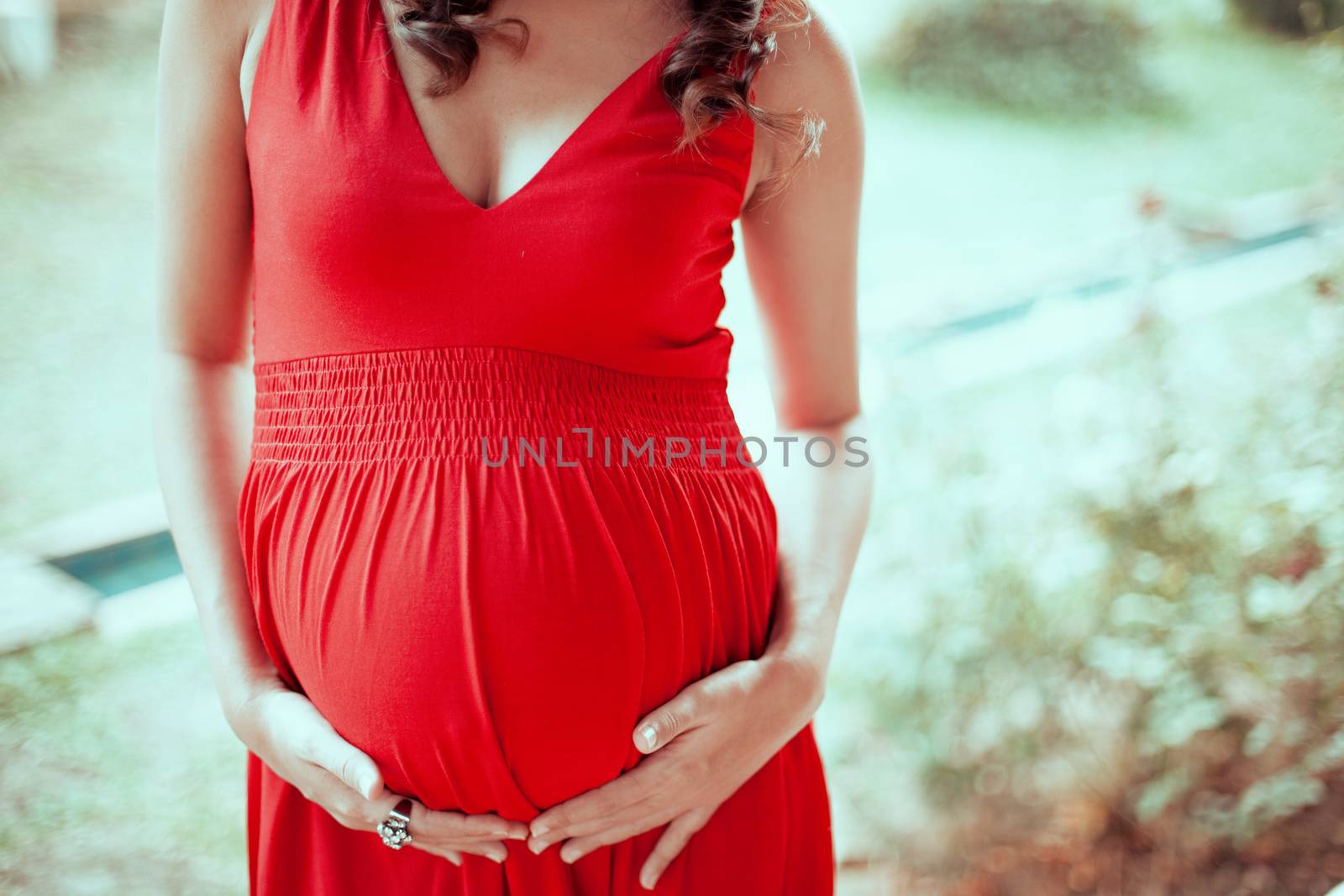 Image of pregnant woman touching her belly with hands