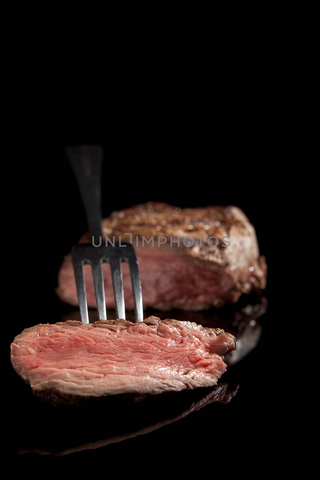 delicious medium rare sliced steak with fork 