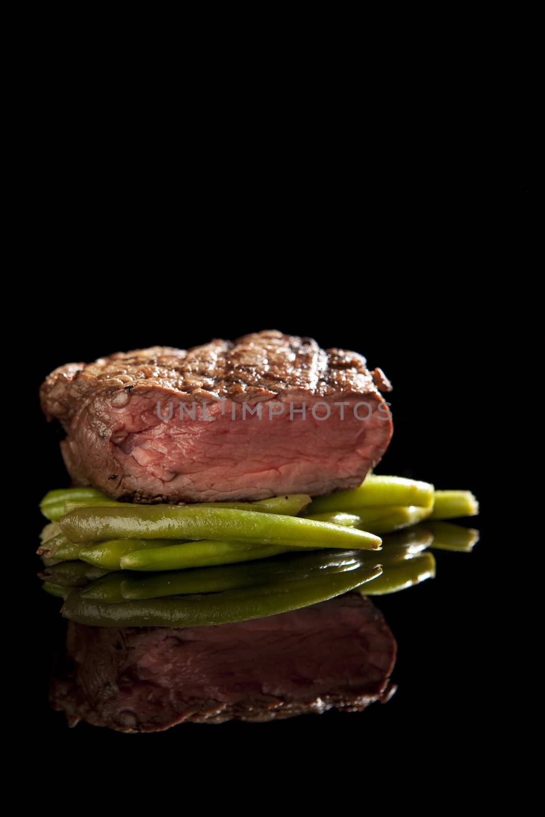 beef steak on black background with beans.