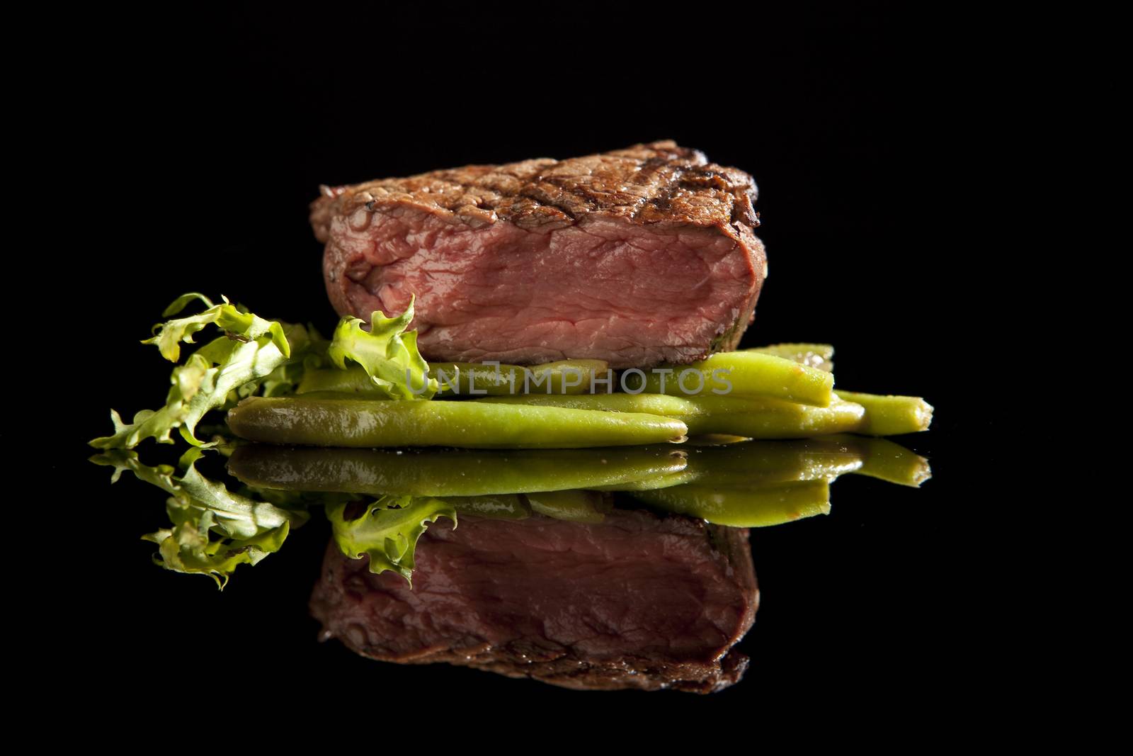 beef steak with salad and beans on black background.