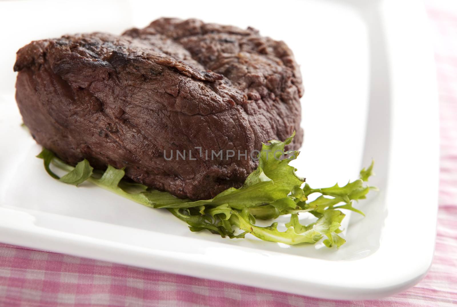 big steak on a plate with salad