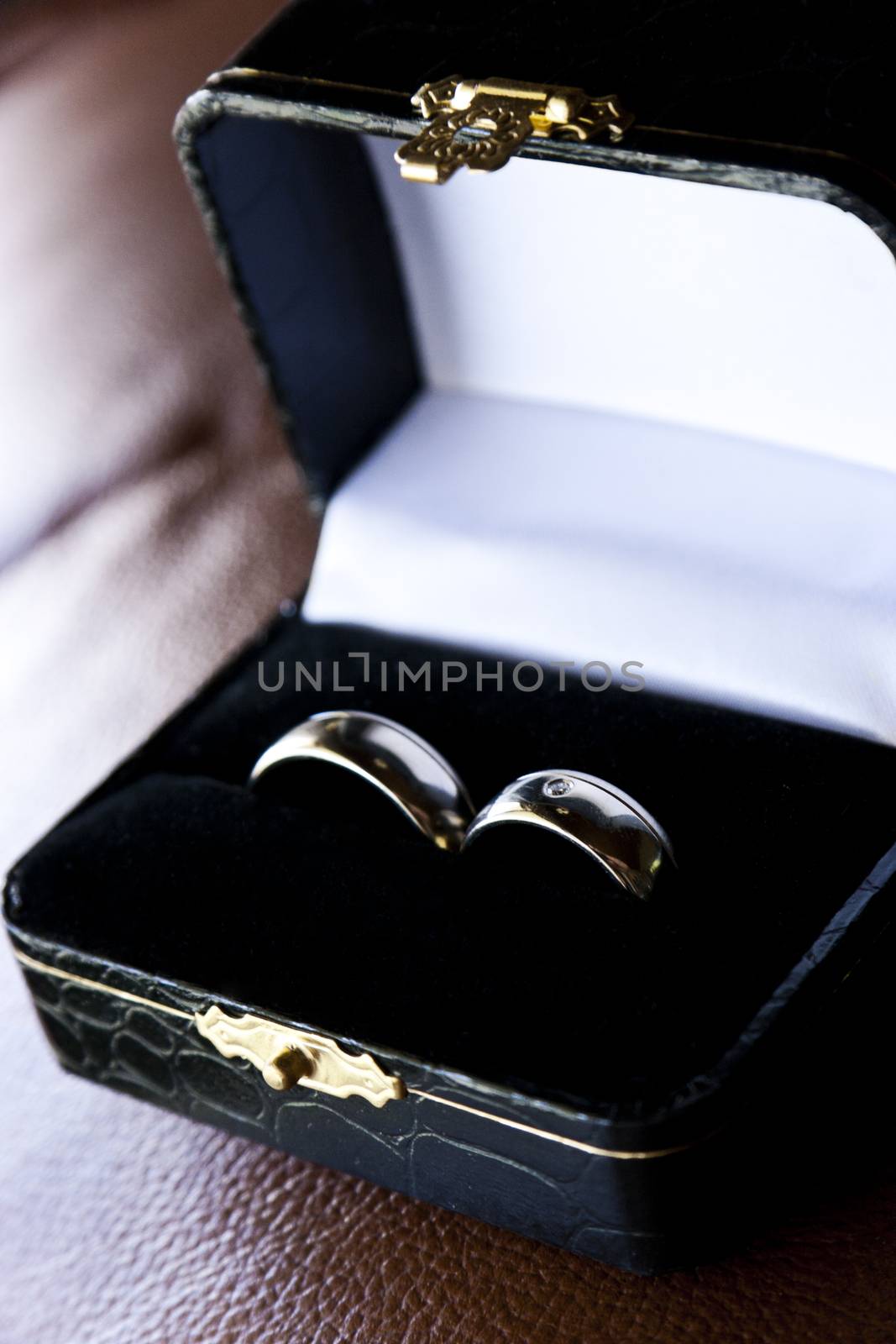 Golden wedding rings in luxurious box on brown background