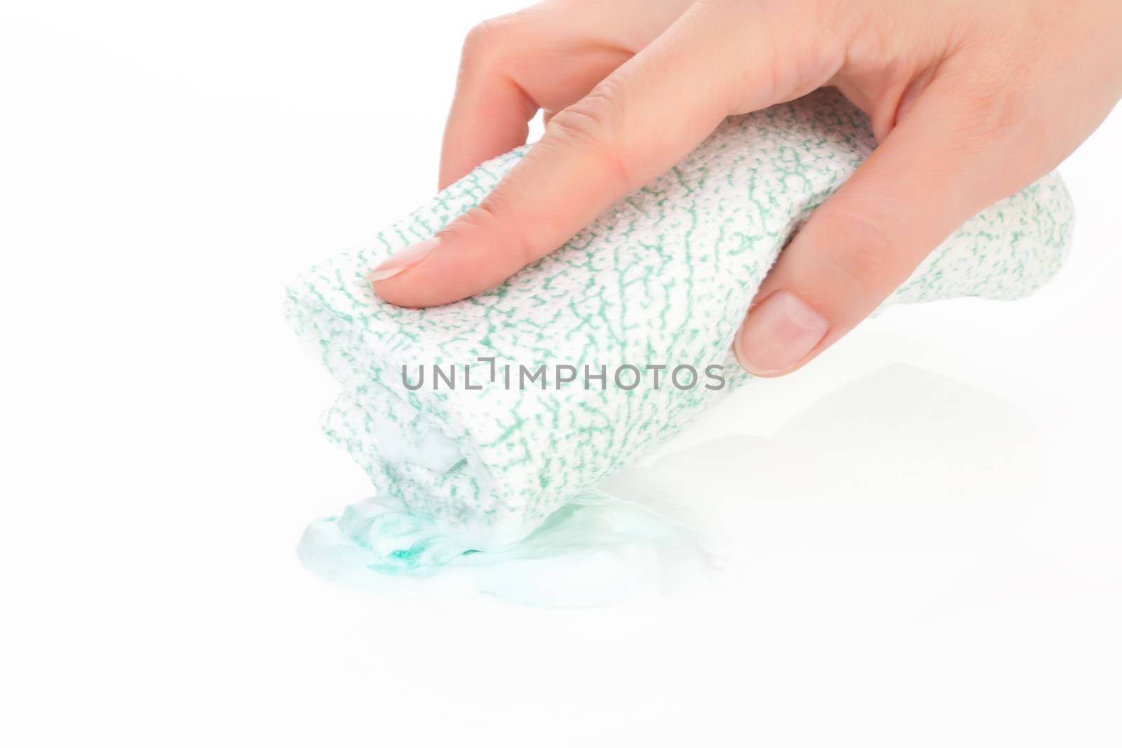 Young female hand holding cleaning sponge dipping into cream soap. Cleaning concept, sparse composition.