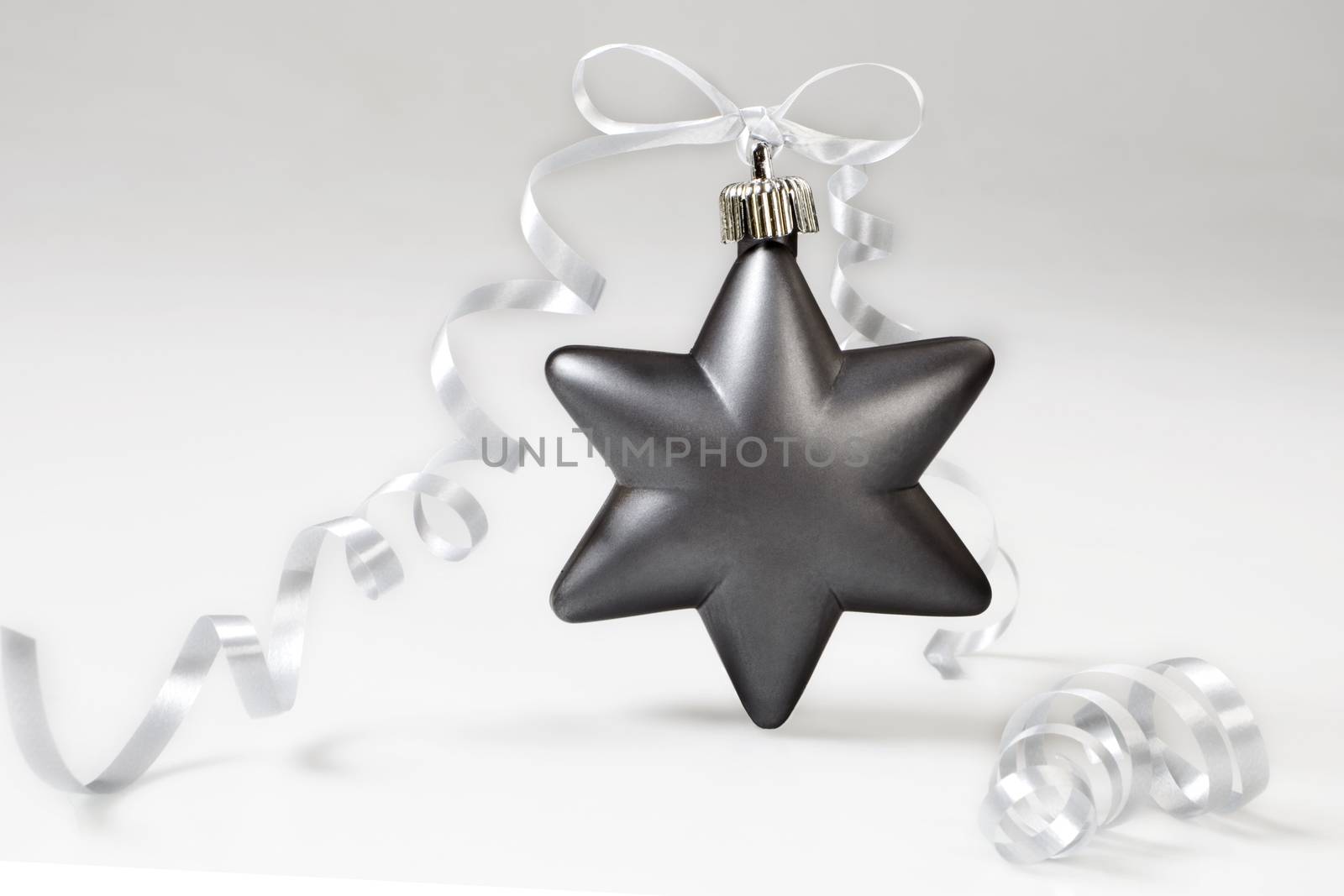 Grey christmas star with bow on white background.