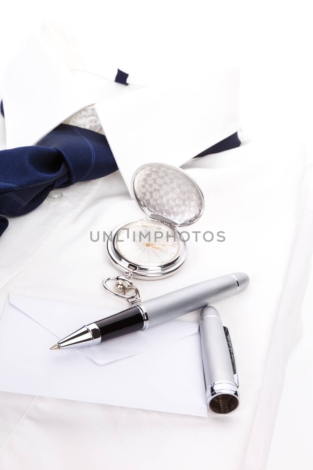Luxurious business still life with white dress shirt, blue tie, pen, envelope and silver pocket watch. Business concept.