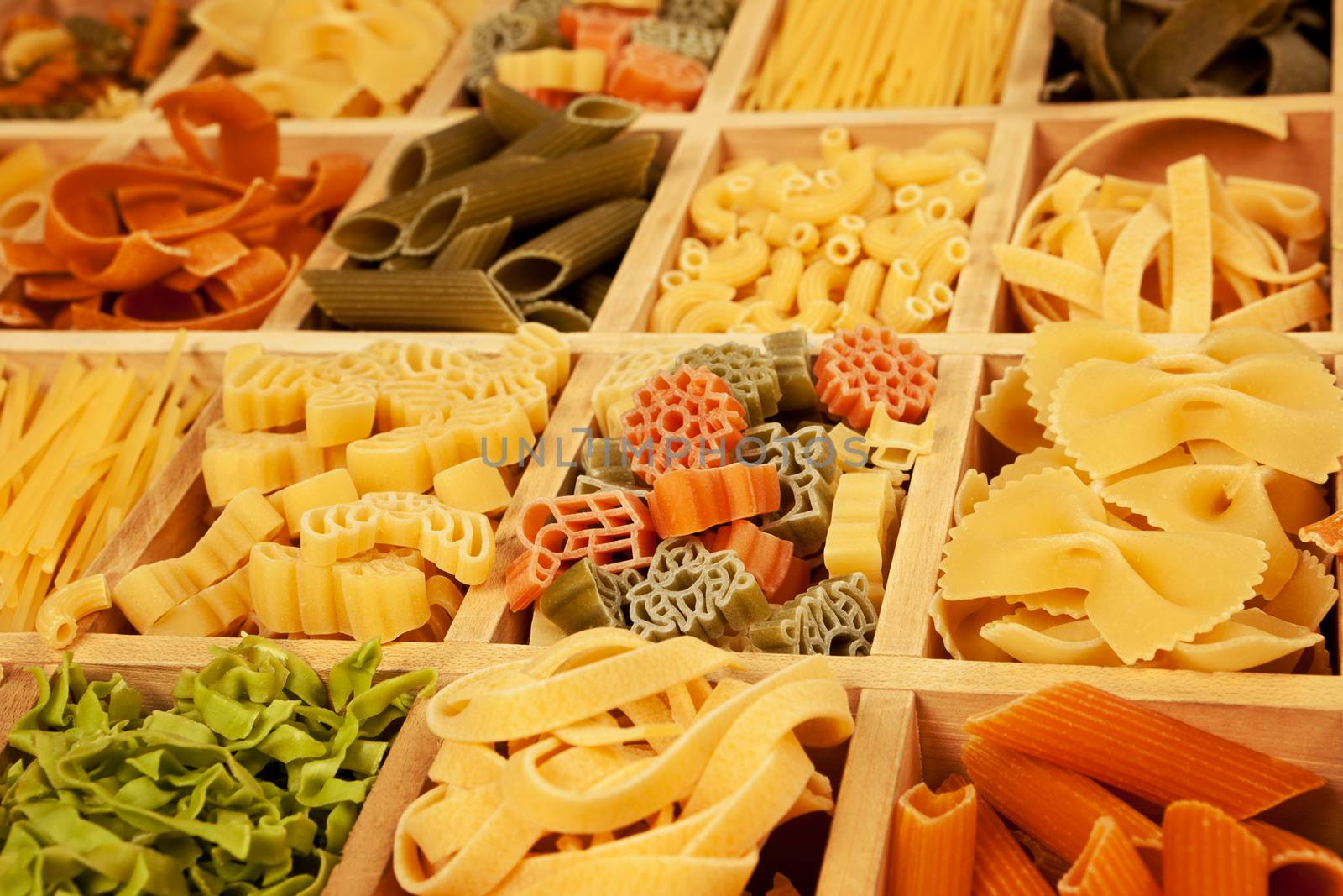 Various colorfull pasta sorts detail in wooden box.