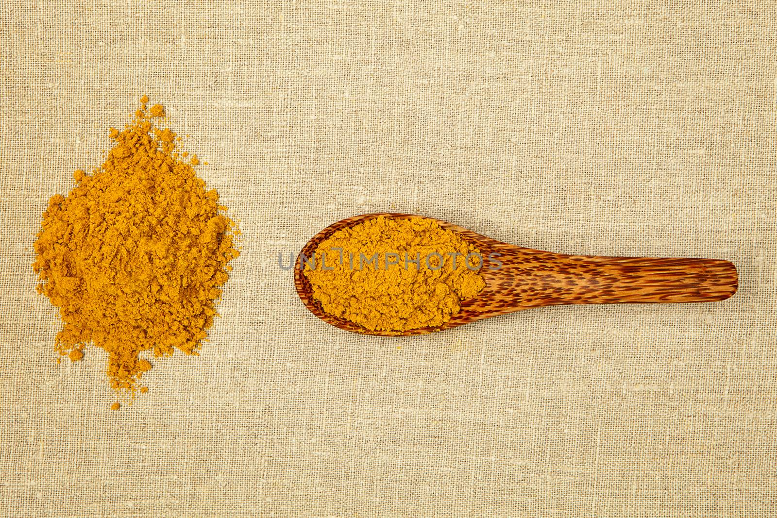 Curry spice on bamboo spoon - top view.