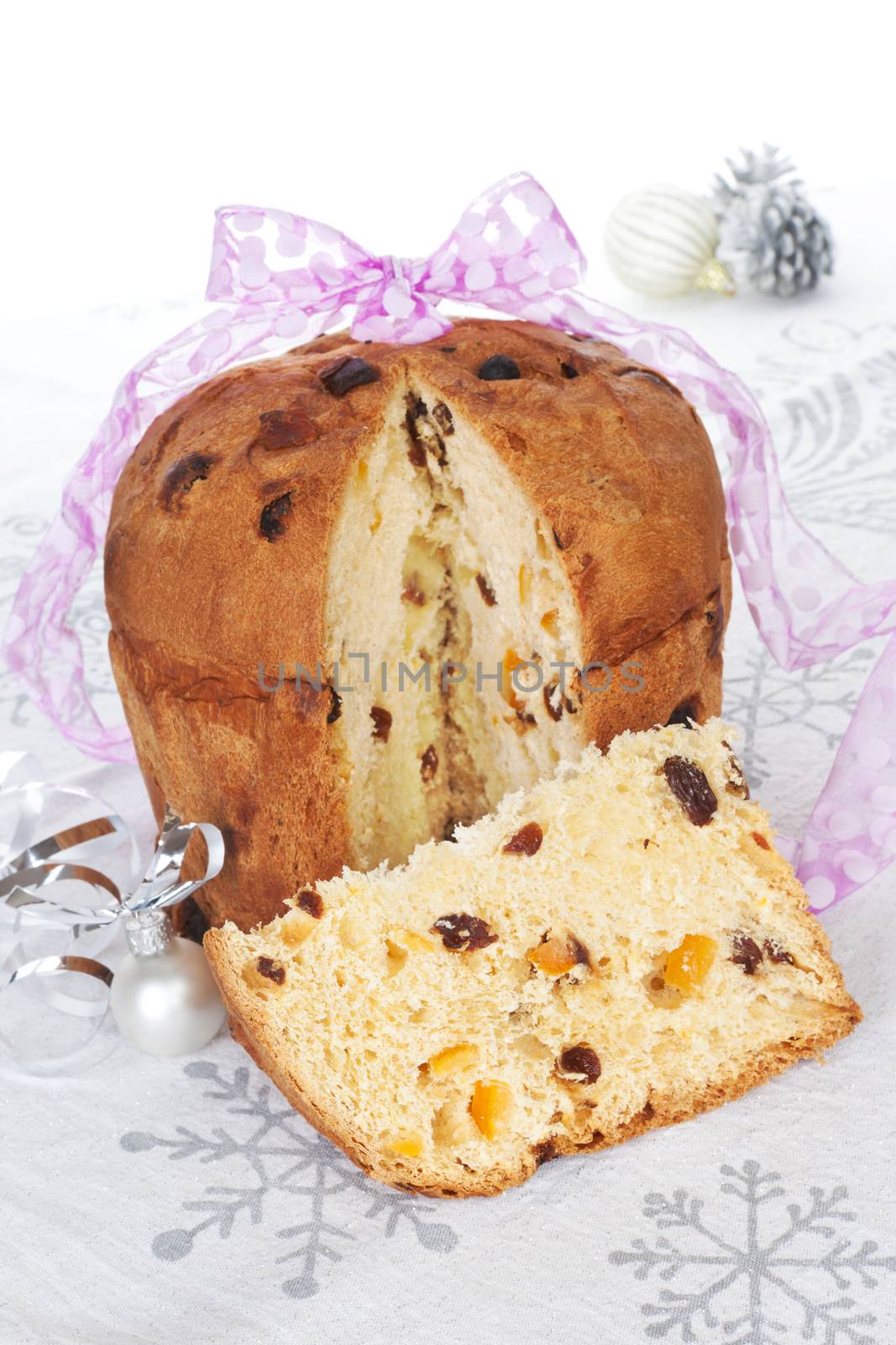 Delicious panettone fruit cake with christmas decoration and ribbon. Festive xmas still life. 