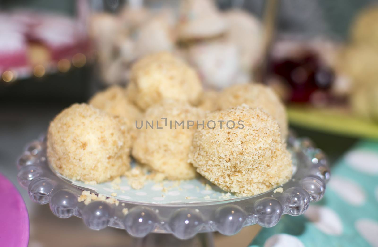 Cheesecake balls on green dotted paper and glass cakeplate, selective focus.