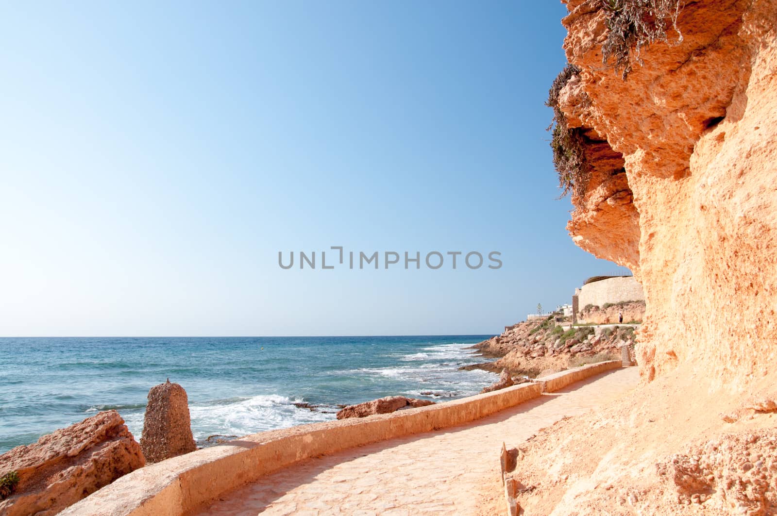 Mediterranean paved walking path with horizon and resorts in the distance in Costa Blanca, Spain.