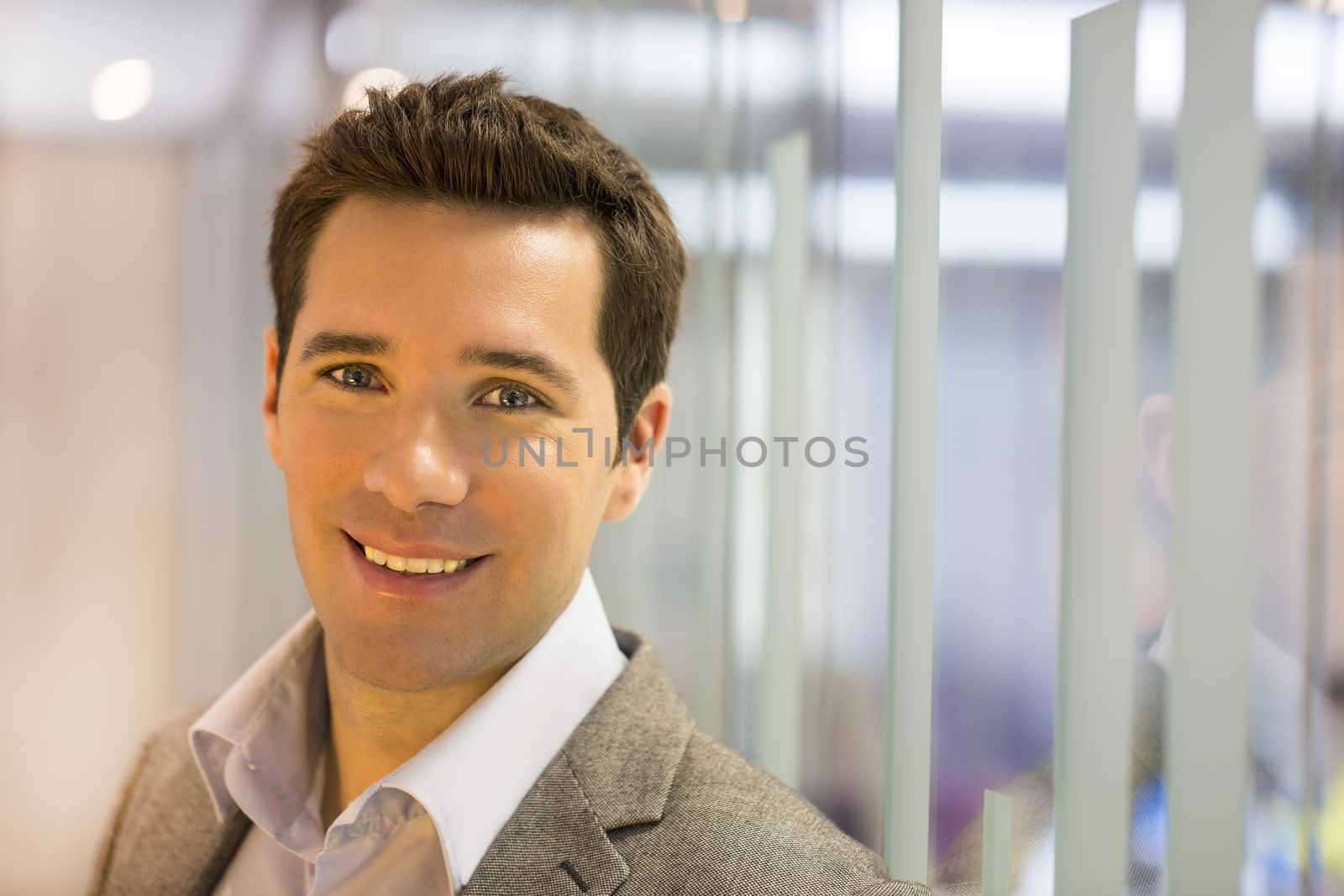 Portrait of smiling businessman standing in hall by LDProd