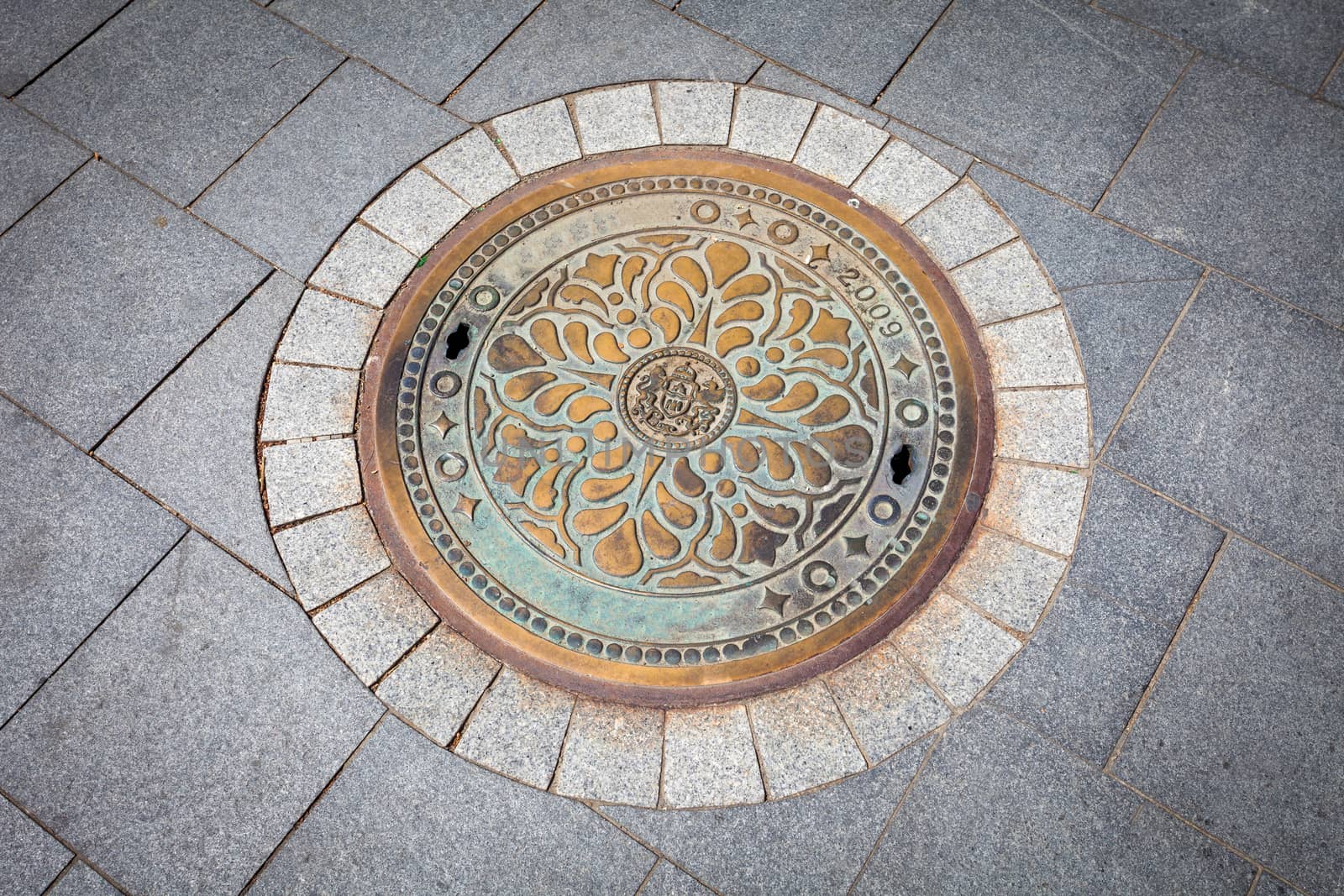 Budapest rusted sewer cap surrounded by pavement granite stones