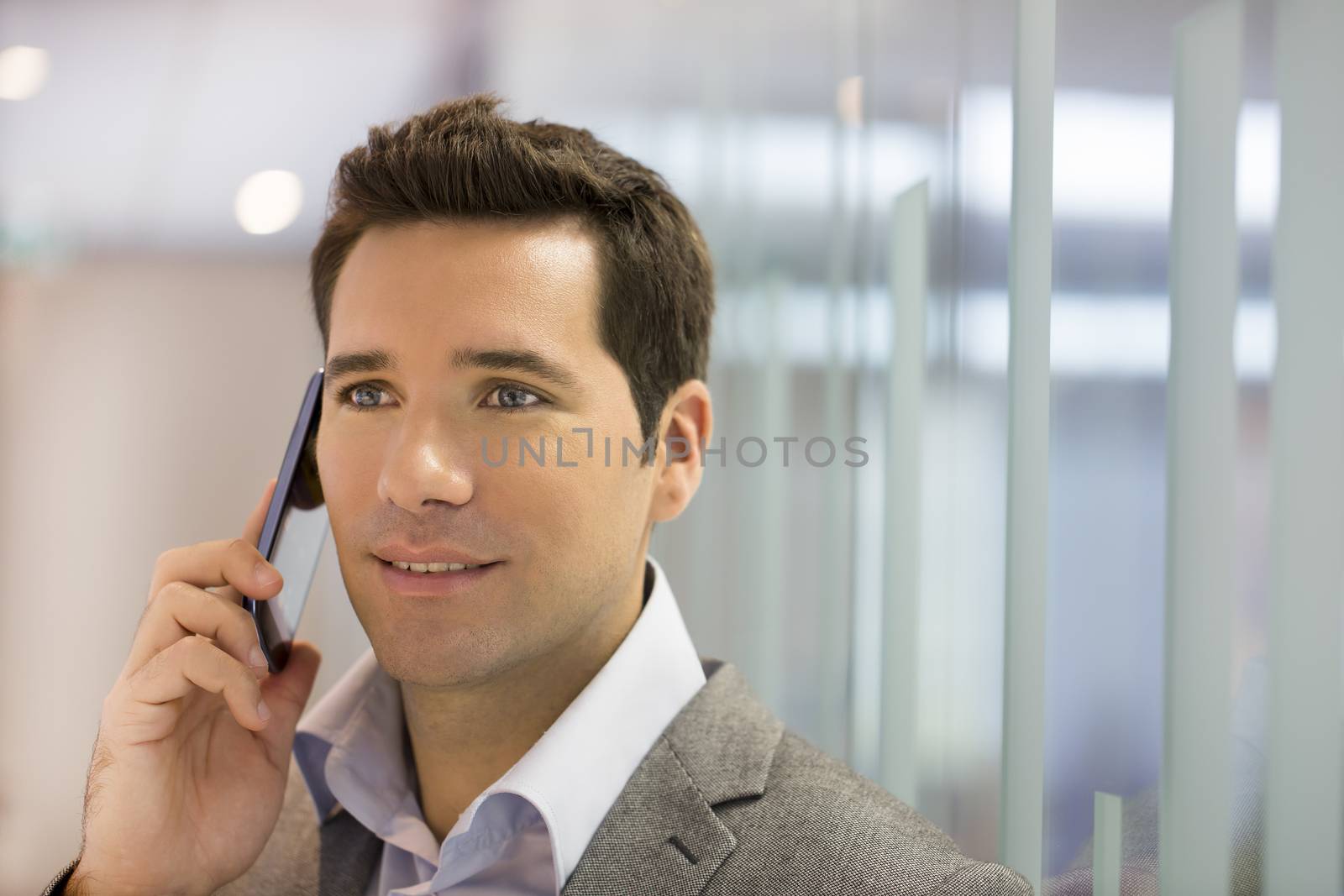 Successful businessman talking on cell phone by LDProd