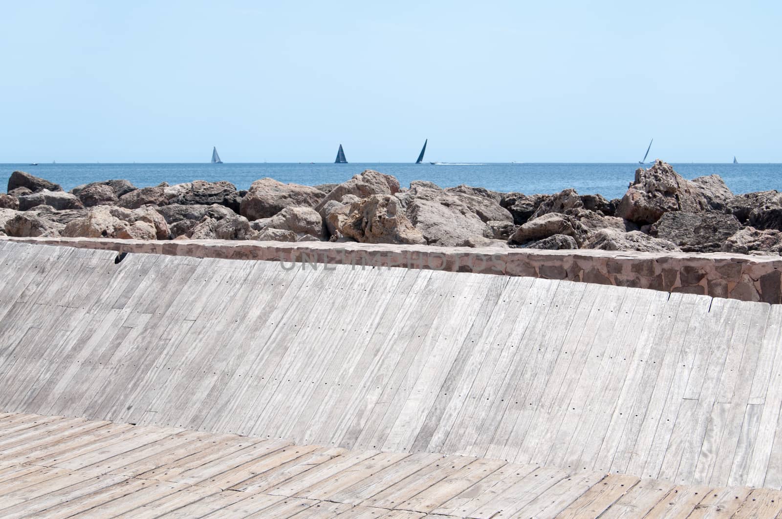 Wood jetty and horizon with sailing boats. Majorca, Balearic islands, Spain.