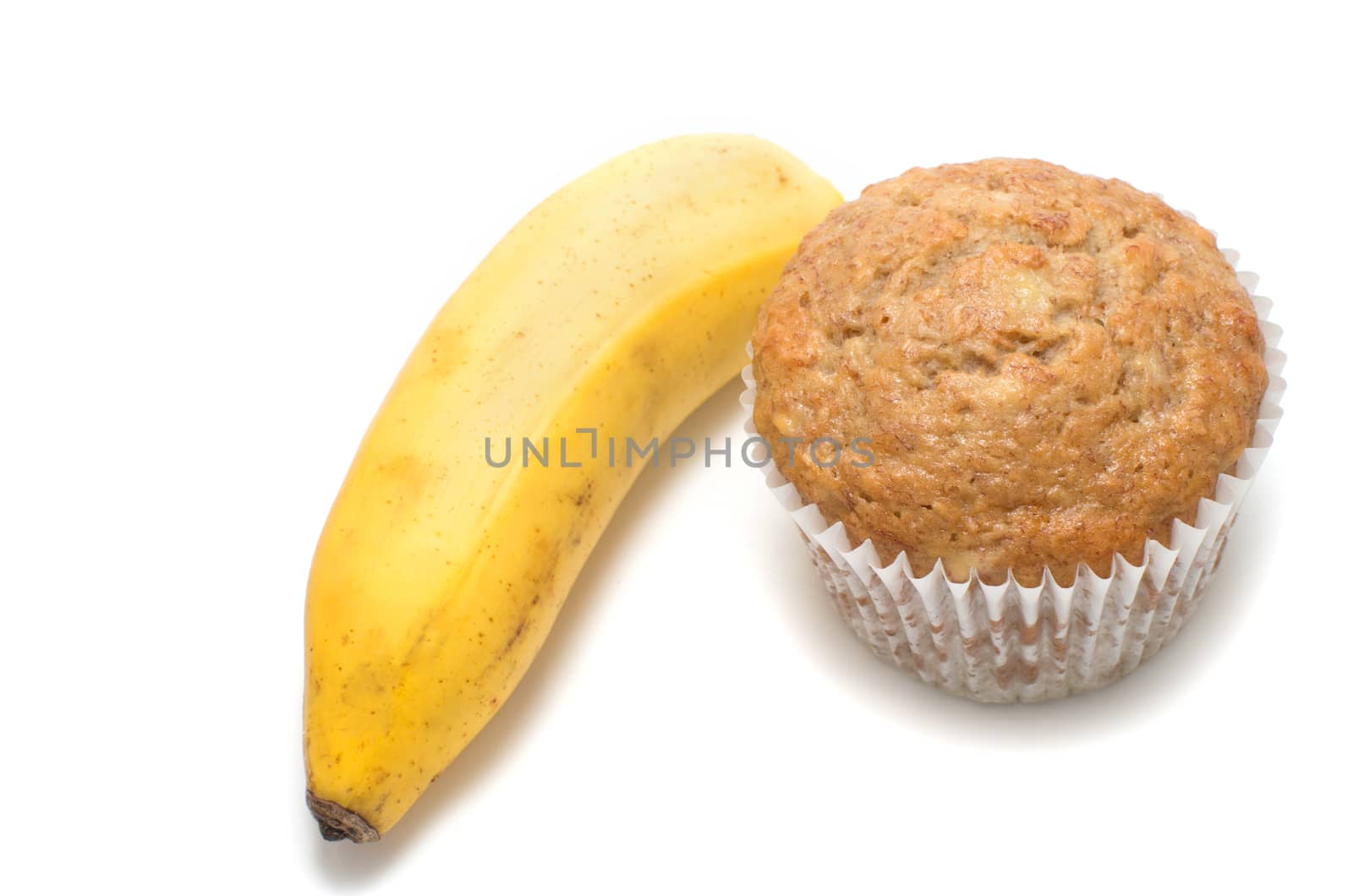 Fresh baked homemade muffin and a banana white background. 