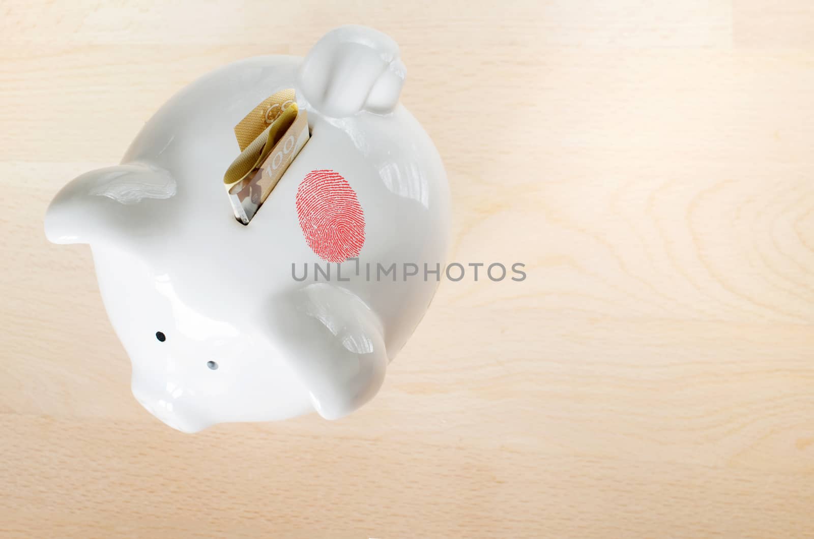 Crime concept with a red fingerprint on white piggy bank